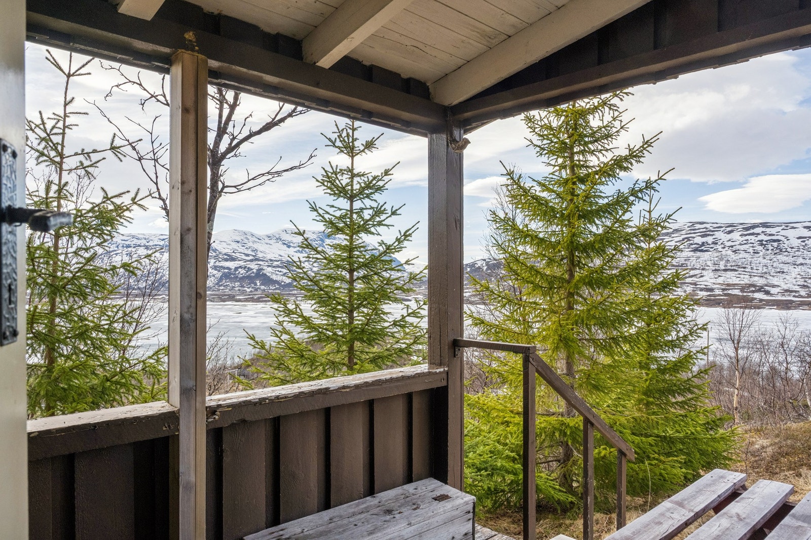 Utsikt mot fjell og natur fra det overbygde inngangspartiet. Galleribilde