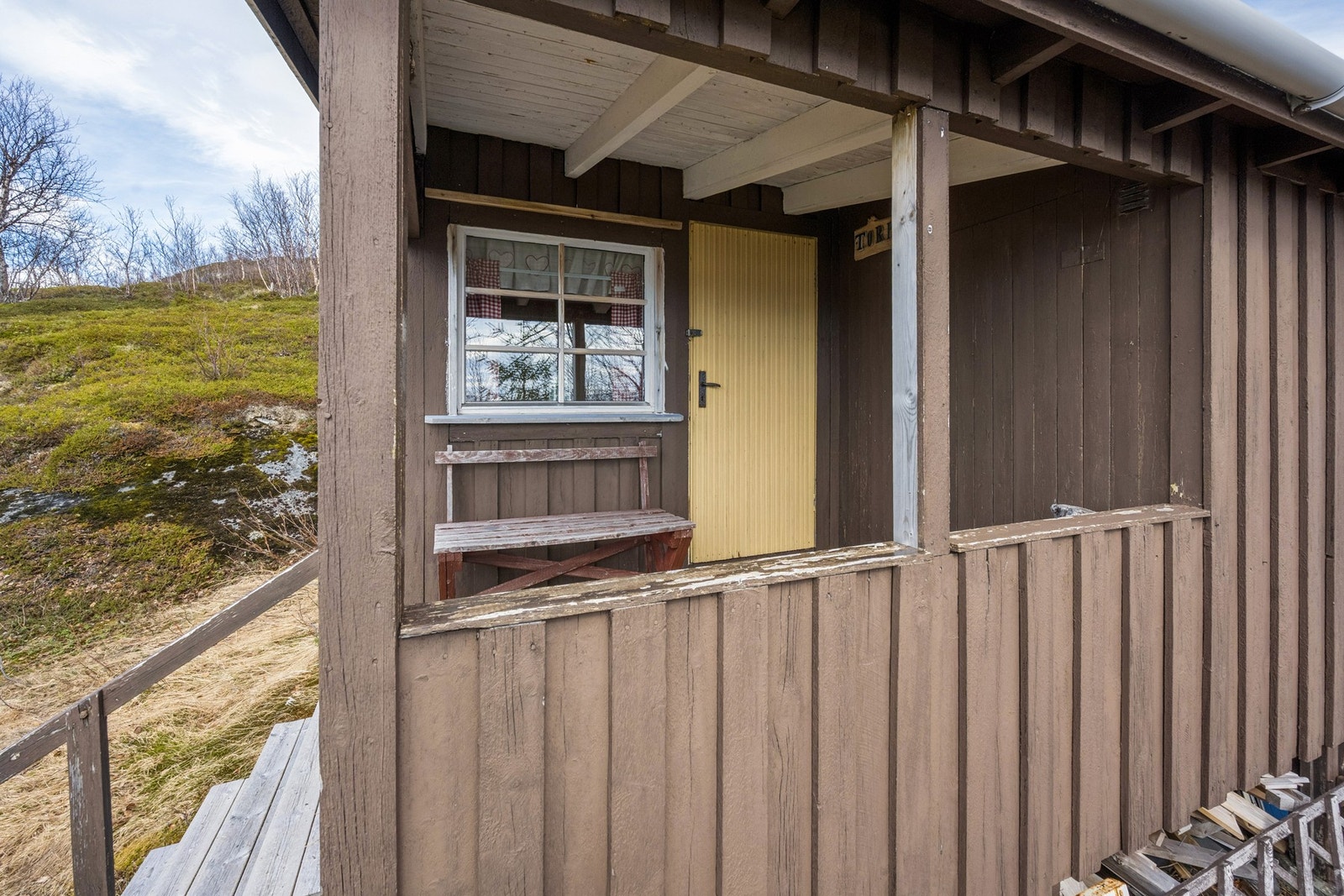 Hytta har stående tømmermannskledning og saltak tekket med takpapp. Galleribilde