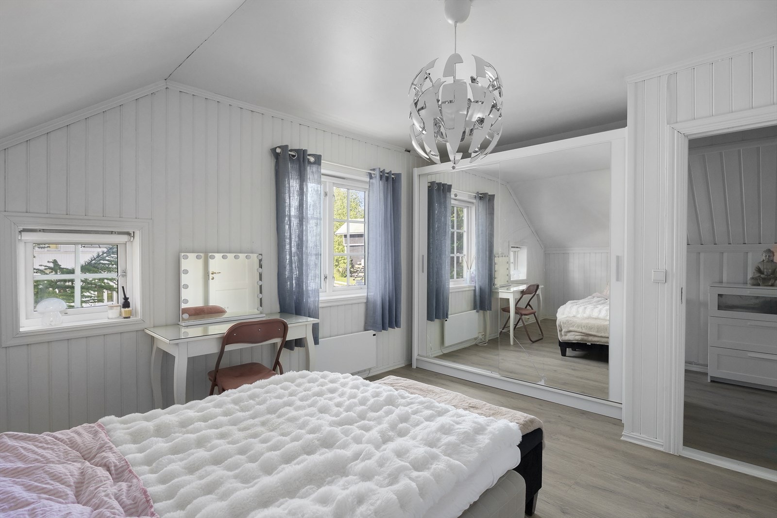 Luftig soverom med skyvedørsgarderobe. Flott gulv, lysmalte vegger og klassiske vinduer med sprosser. Galleribilde