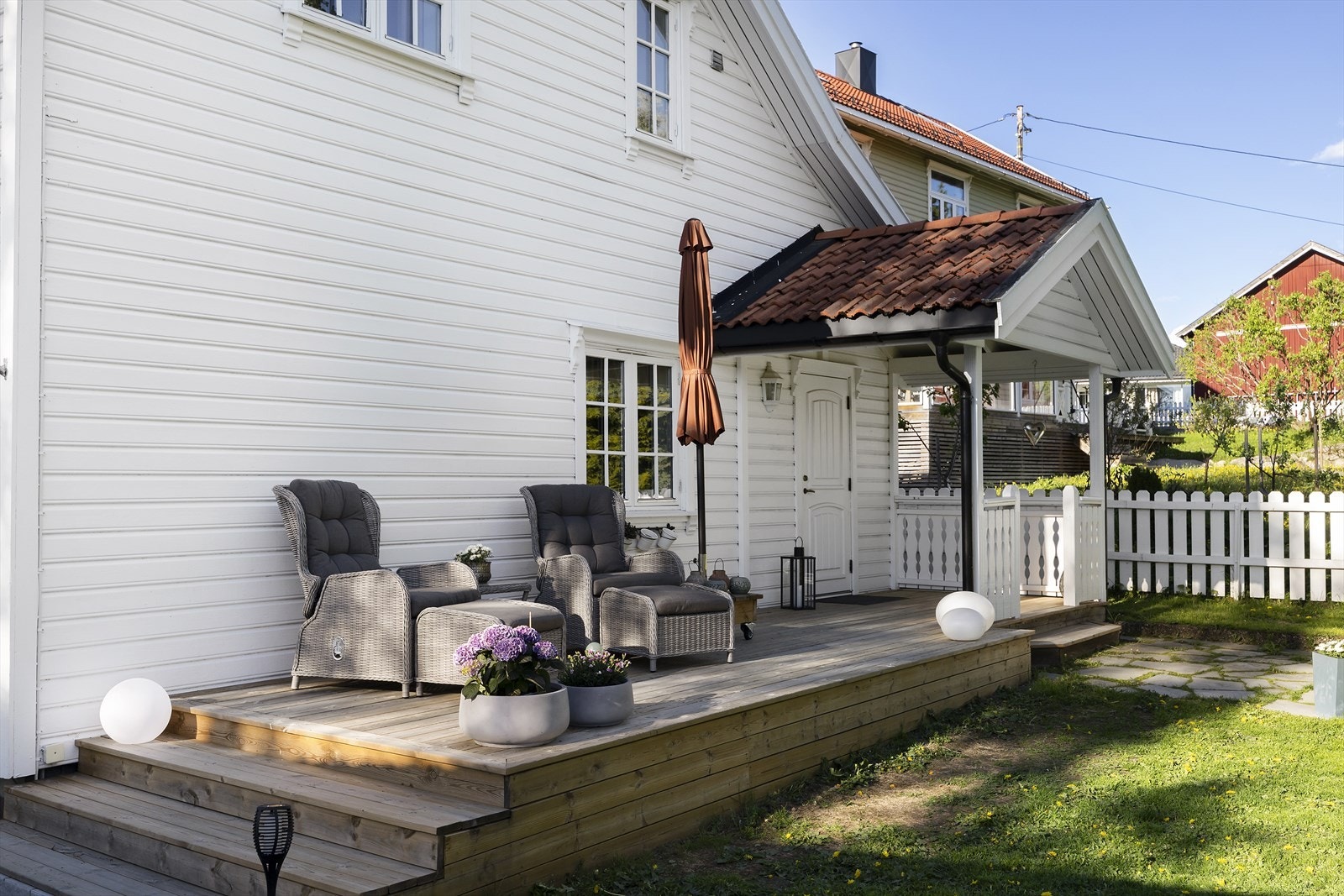 Hyggelig platting med sitteplass som leder videre til overbygget inngangsparti. Galleribilde
