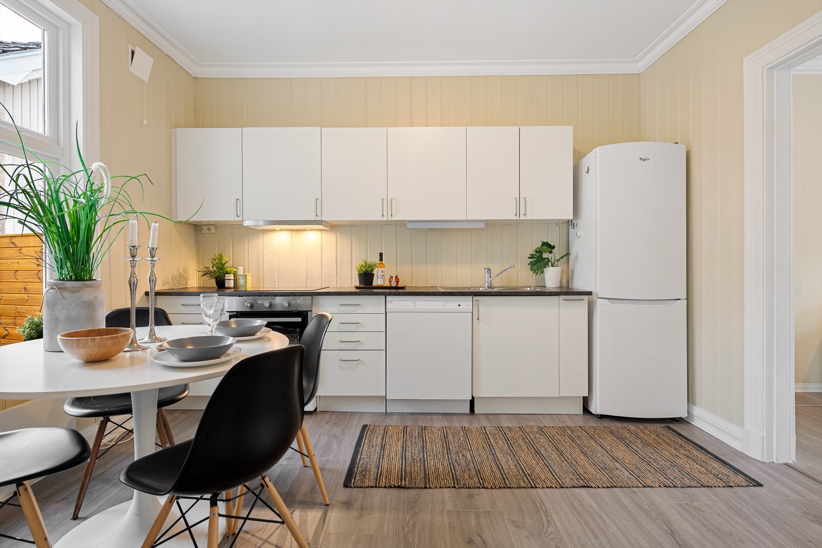 Innredningen har slette fronter og laminat benkeplater med nedfelt vaskekum. Det er opplegg for oppvaskmaskin og kjøkkenventilator med avtrekk ut over avsatt plass til komfyr. Galleribilde