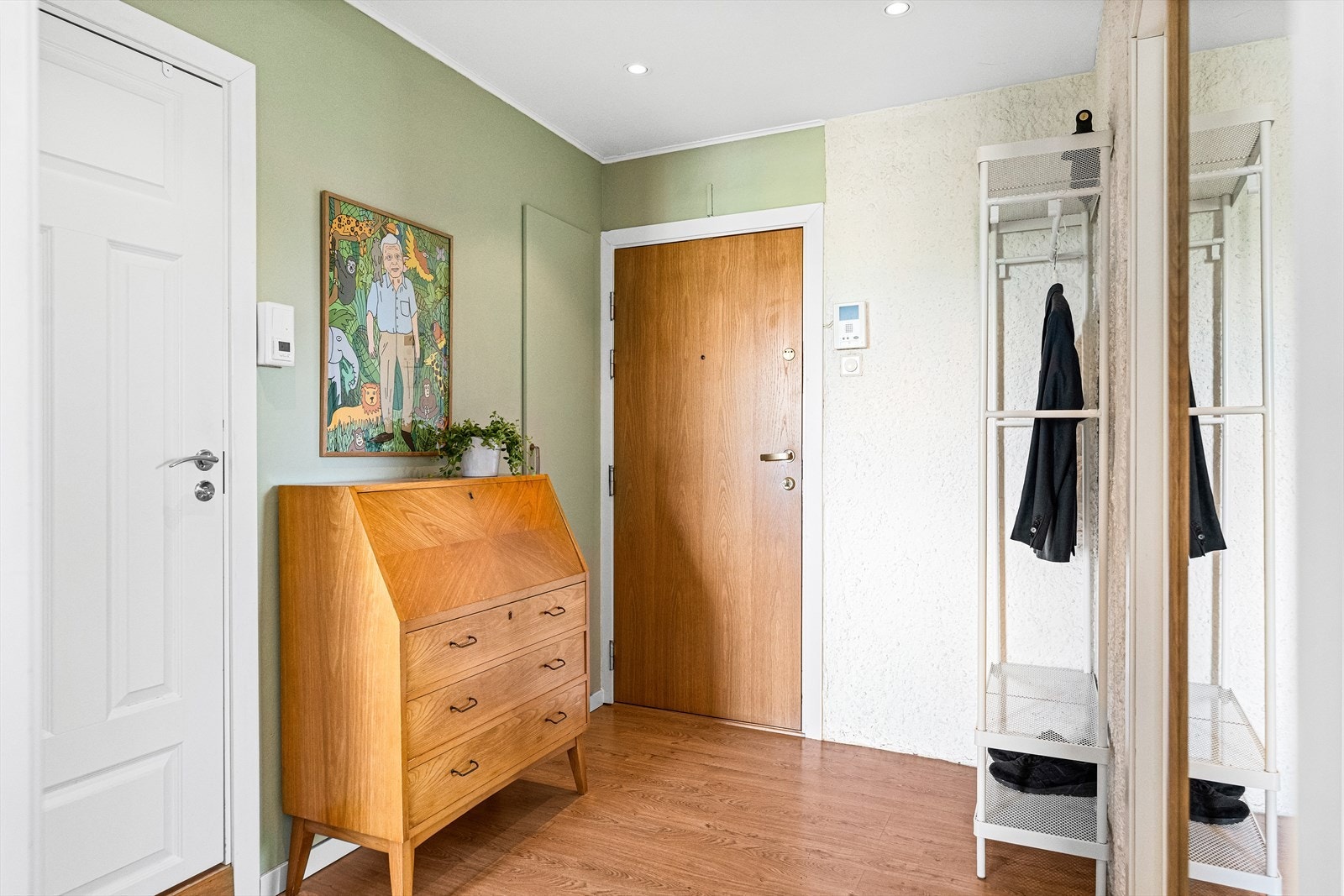 Leiligheten har en innbydende og lys entré, med plass til å henge fra seg yttertøy og sette fra seg sko. Galleribilde
