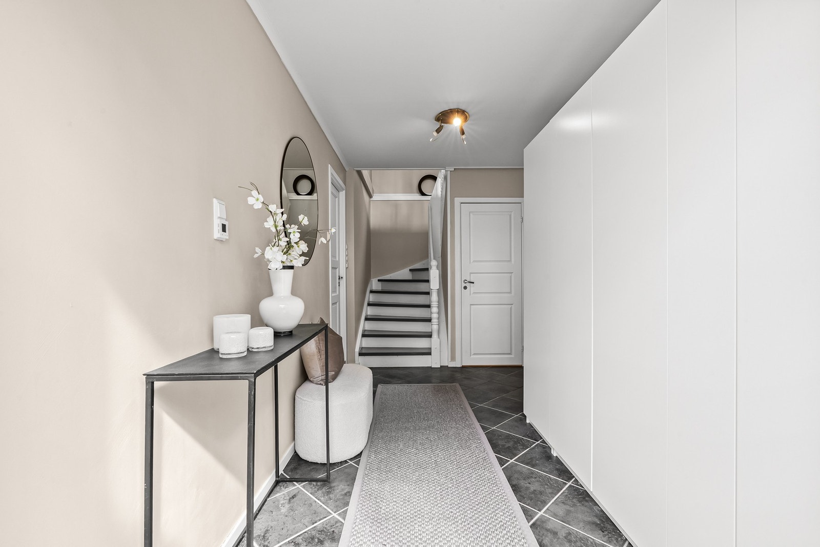 I underetasjen blir man ønsket velkommen inn i en flott entré med lysmalte vegger og fliser på gulvet med gulvvarme. Galleribilde