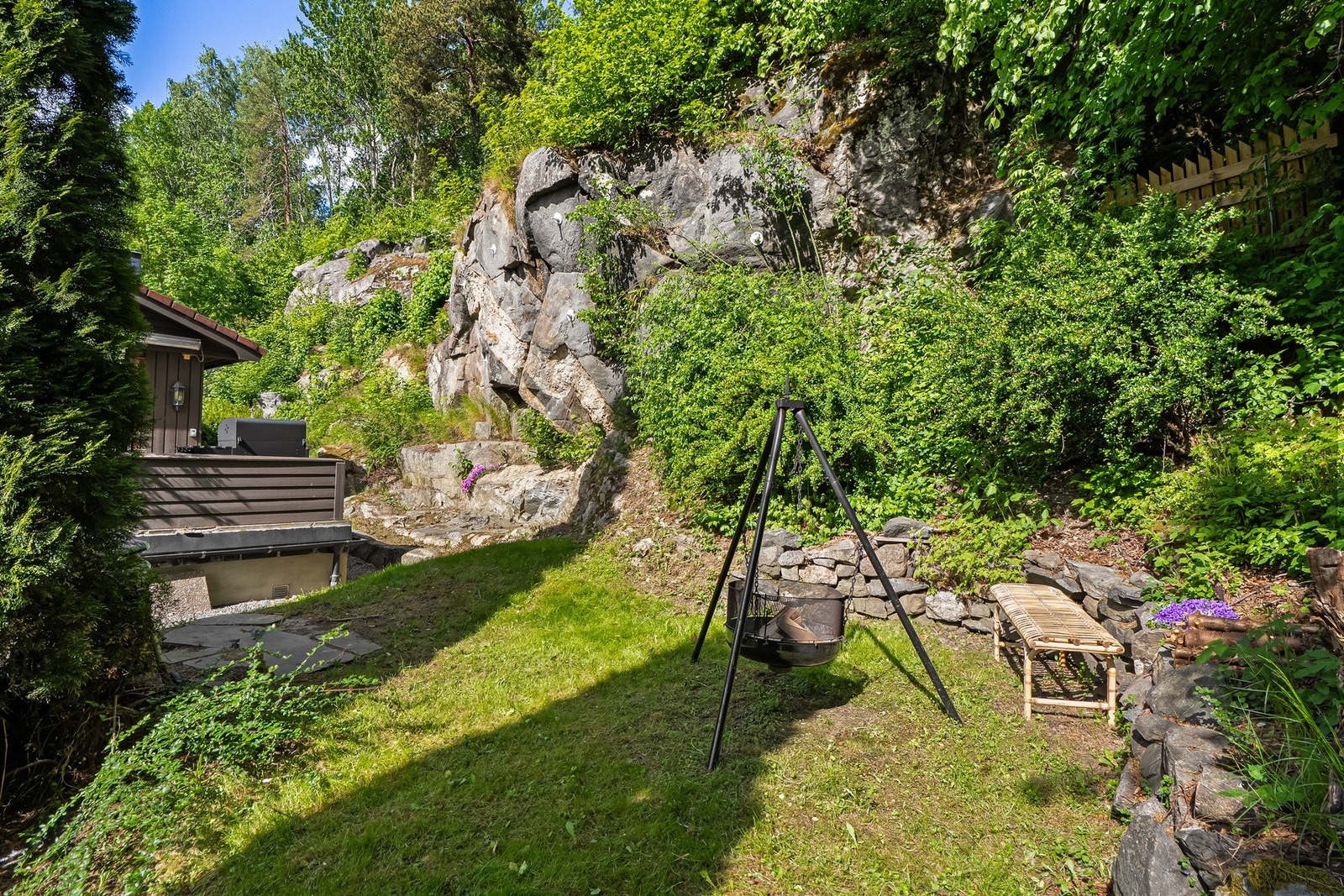 Tomten er opparbeidet med gressplen, prydbusker, beplantning og fjell i dagen. Galleribilde