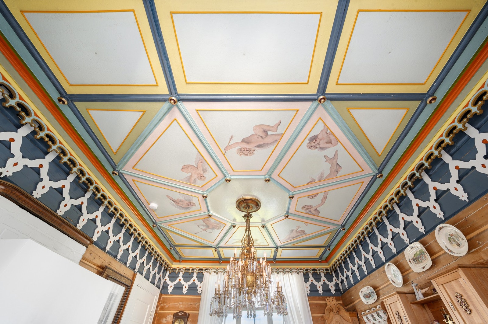 Originale tømmervegger og tregulv, håndmalt kunst i taket, friske og levende farger - rommet har et helt eget og unikt særpreg. Galleribilde
