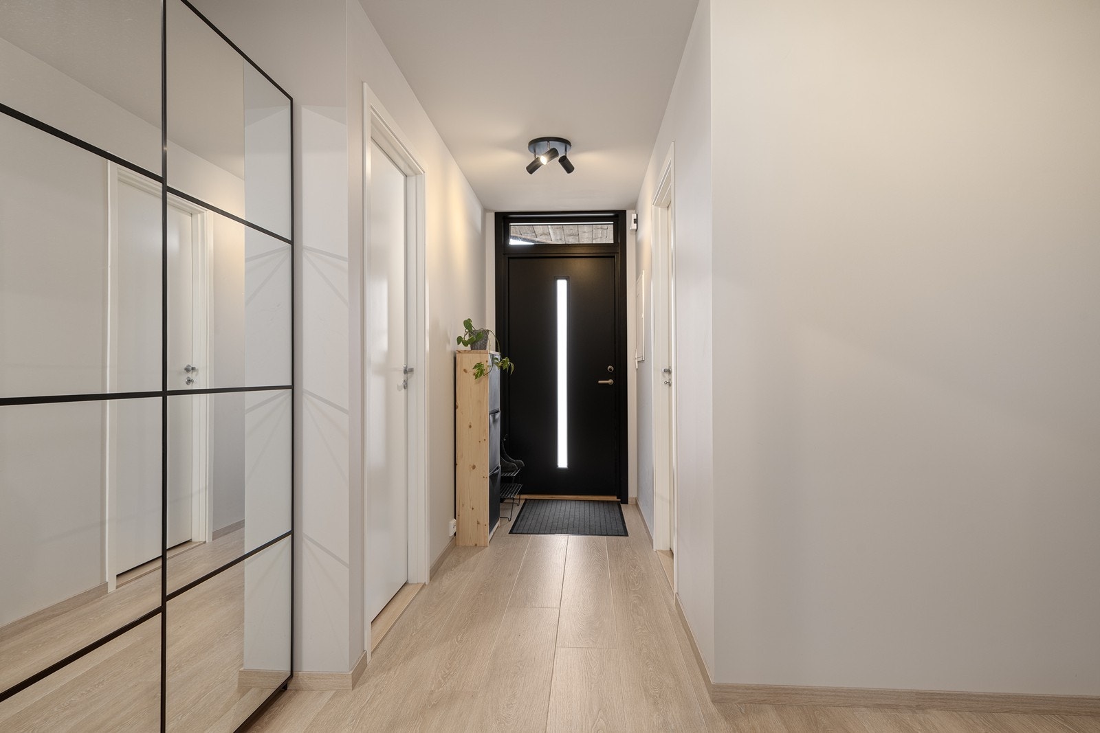 Romslig entré med god oppbevaringsplass i skyvedørsgarderobe med speil Galleribilde
