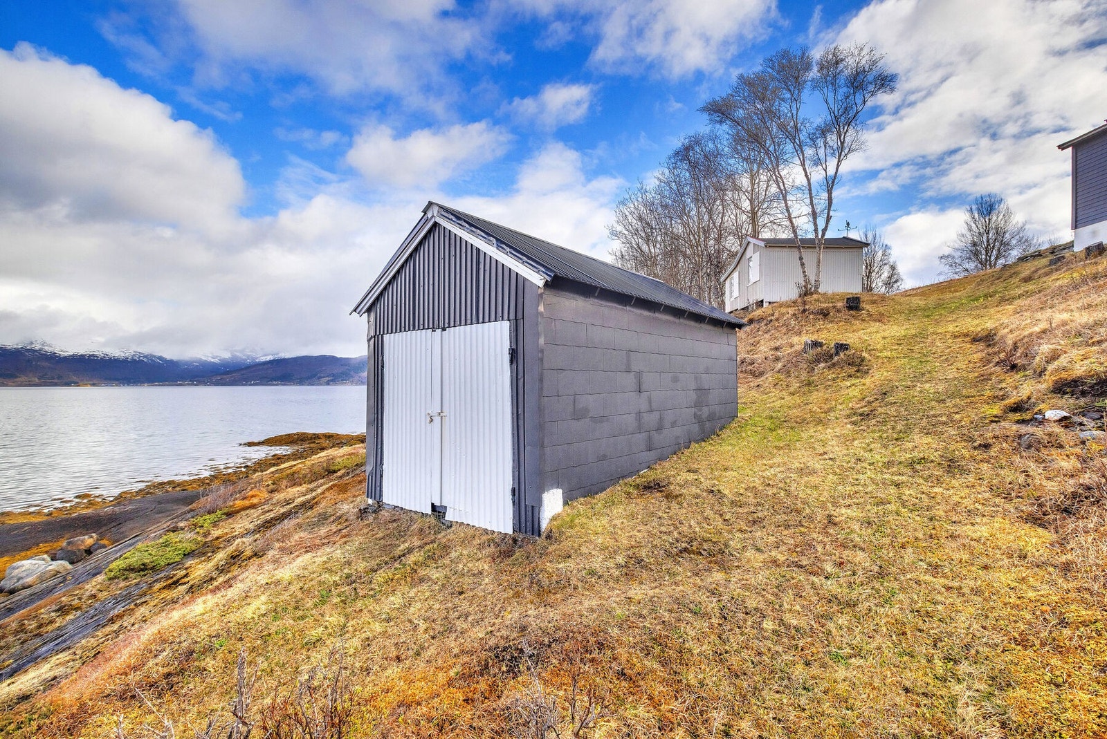Naustet på ca. 16 m² ligger nede ved sjøen. Galleribilde