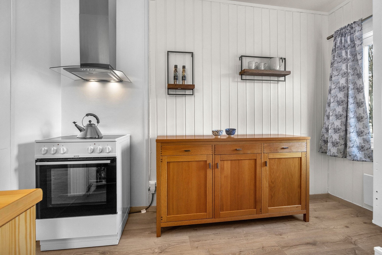 Kjøkkenventilator med kullfilter er montert over komfyren. Galleribilde