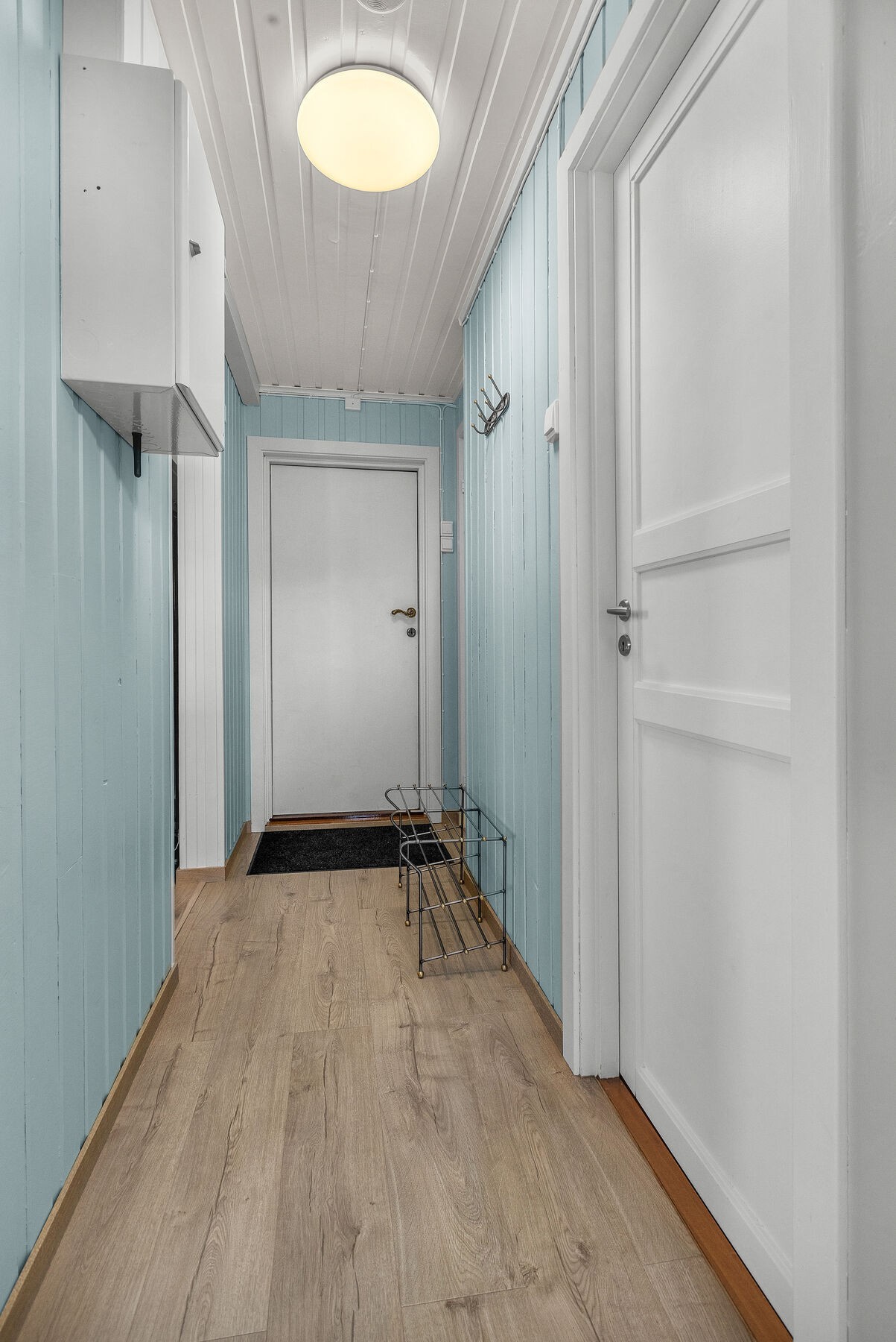 Entré med adkomst til hyttas øvrige rom. Overflater med laminatgulv og malt trepanel. Galleribilde