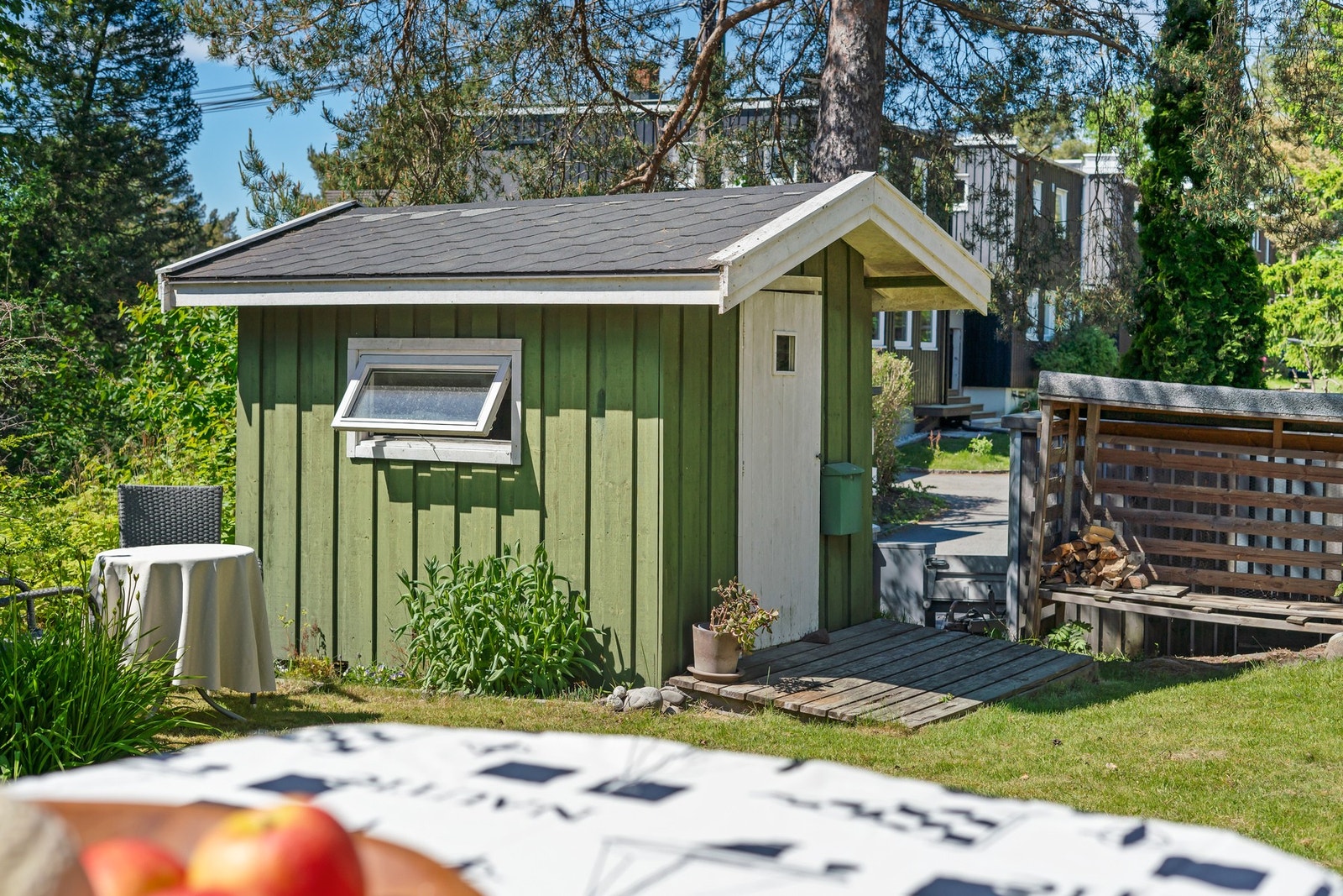 Pen, opparbeidet hage med gressplen og beplantning med et lite uthus. Galleribilde