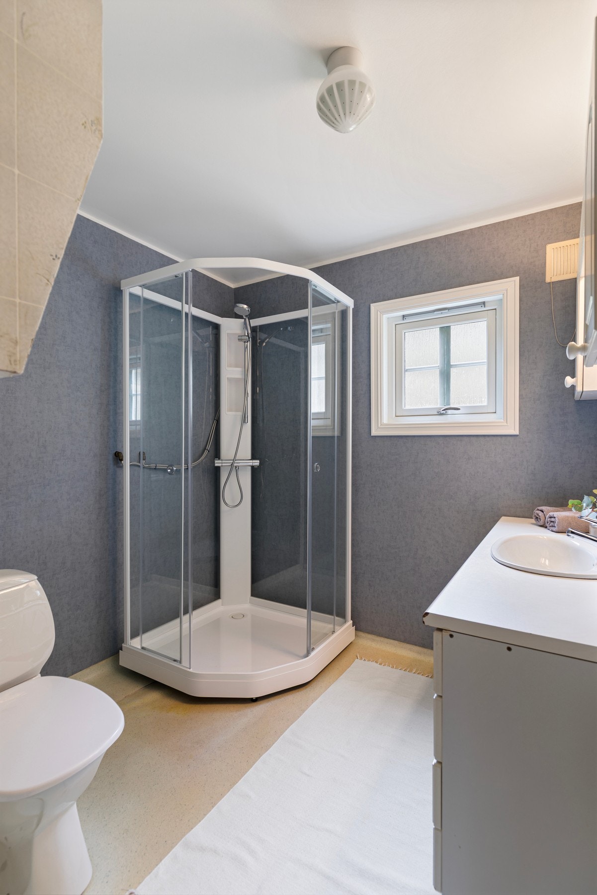 Badet i etasjen er fra 80-tallet. Rommet har belegg på gulv og våtromstapet på vegger. Badet er utstyrt med toalett, dusjkabinett og baderomsinnredning. Galleribilde