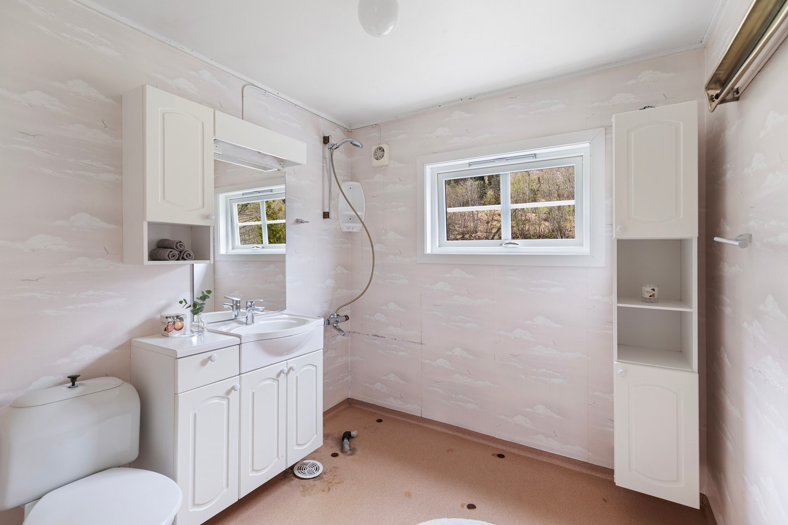 Badet i etasjen er av eldre standard og har behov for renovering. Rommet har belegg på gulv og våtromstapet på vegger. Galleribilde