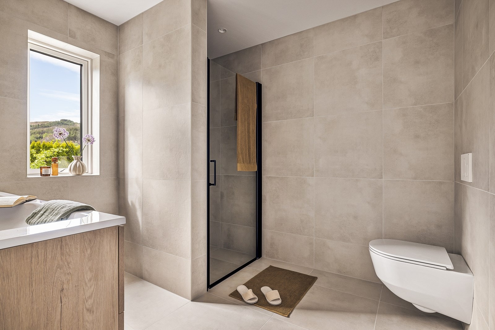 Badet inneholder bla moderne fliser på gulv og vegger samt dusj, servant, og toalett. Galleribilde