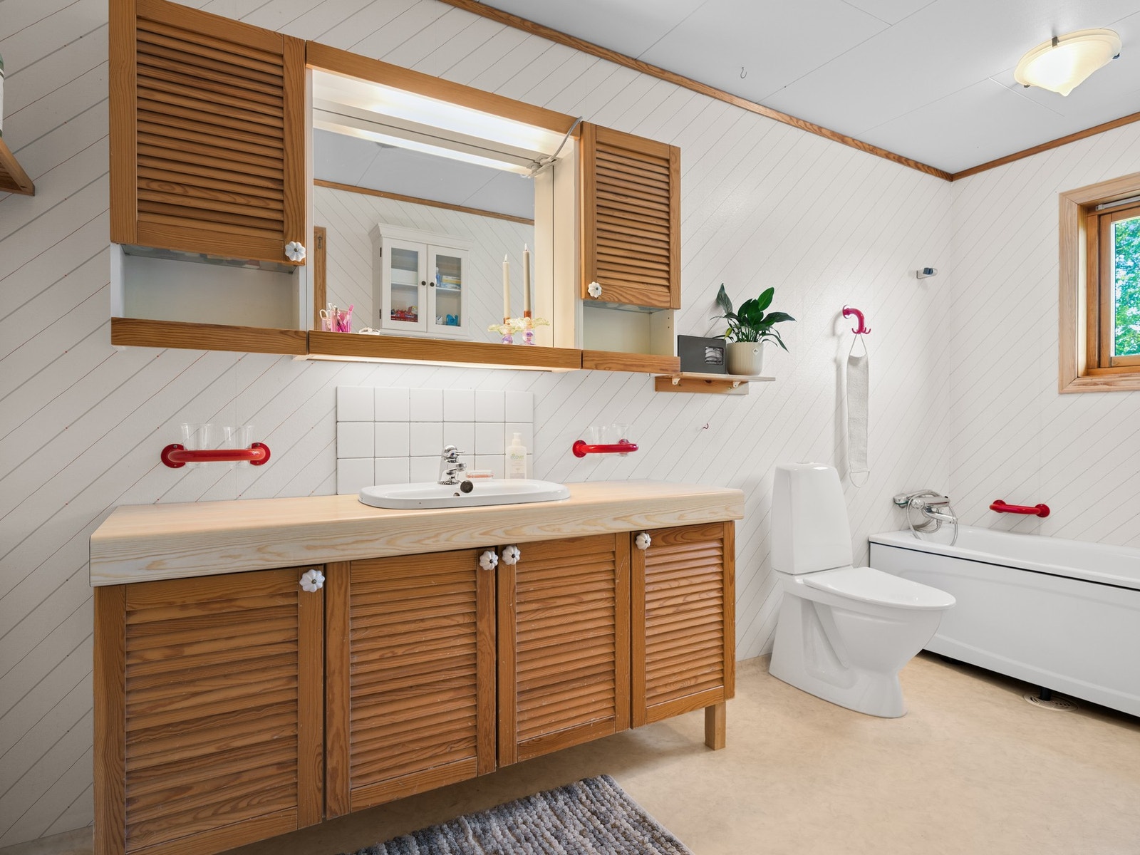 Badet i første etasje har belegg på gulv og våtromtapet på vegger. Badet er innredet med servant på skapseksjon og speil. Videre er badet utstyrt med toalett og badekar. Galleribilde