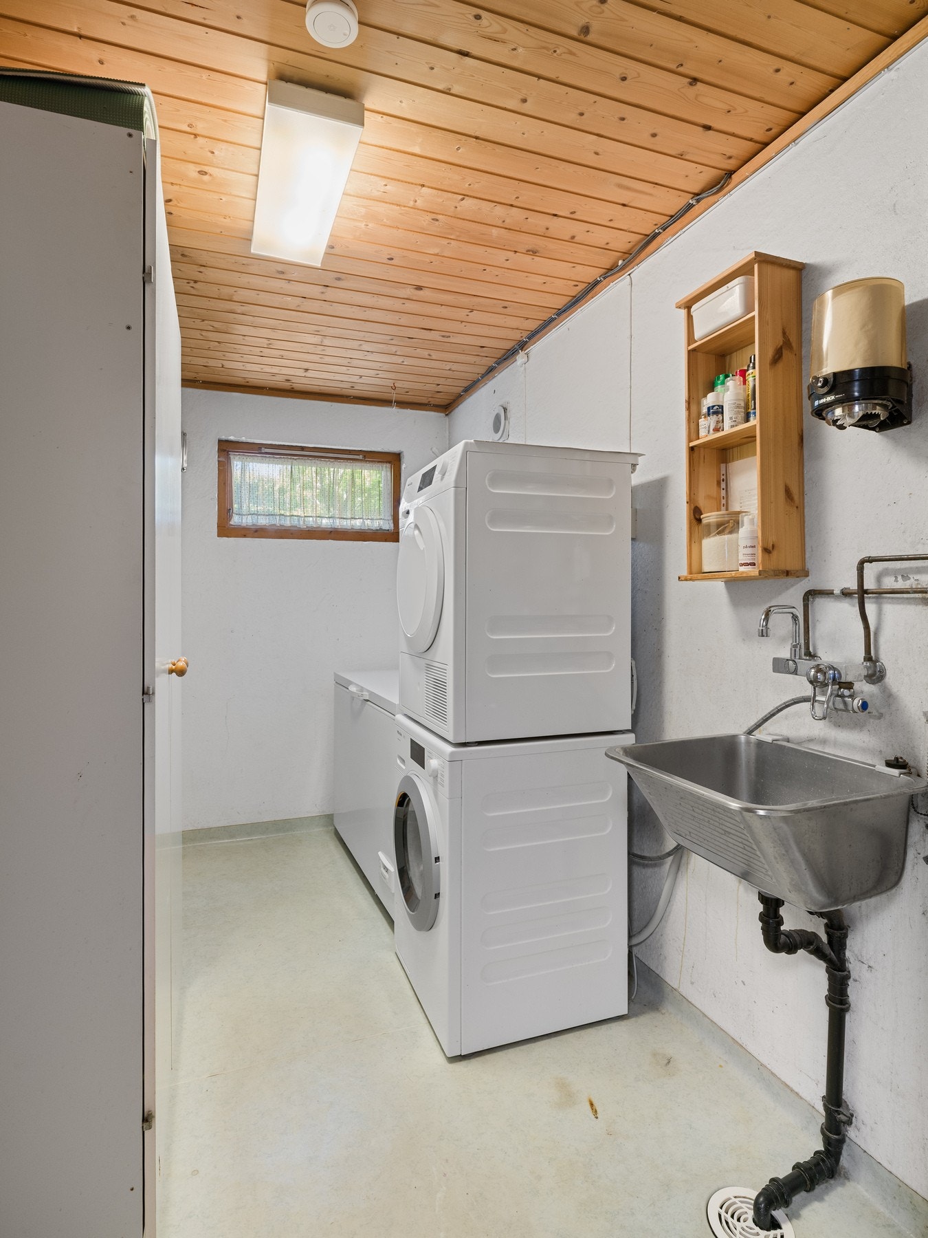 Vaskerommet har belegg på gulv og malte overflater på vegg. Rommet et utstyrt med utslagsvask og opplegg for vaskemaskin. Vaskerommet er en funksjonell og romslig plass som gjør hverdagslige gjøremål lettere og mer effektive. Galleribilde