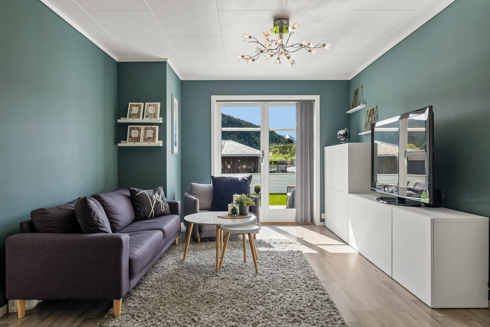 Stuen får godt med naturlig lys inn fra doble terrassedører. Galleribilde
