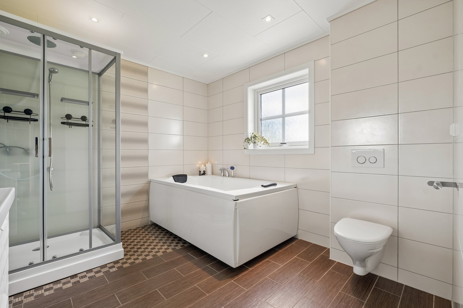 Badet har god størrelse med et areal på ca. 10.4 kvm. Pent helfliset med elektriske varmekabler i gulvet. Downlights i himling. Galleribilde