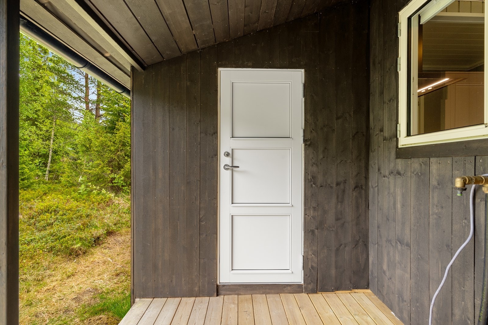 Praktisk sideinngang fra den overbygde delen av terrassen. Vannpost til vegg. Galleribilde