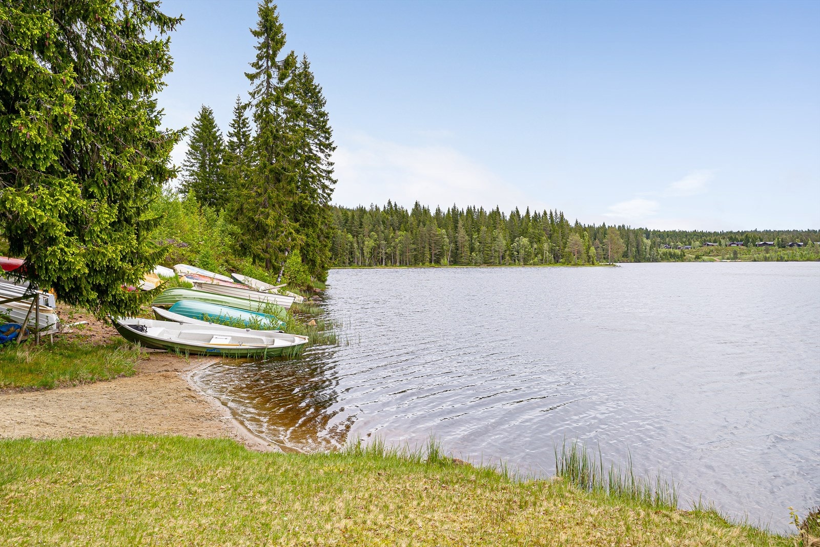 En liten sandstrand ved vannet inviterer til bading på varme sommerdager. Galleribilde