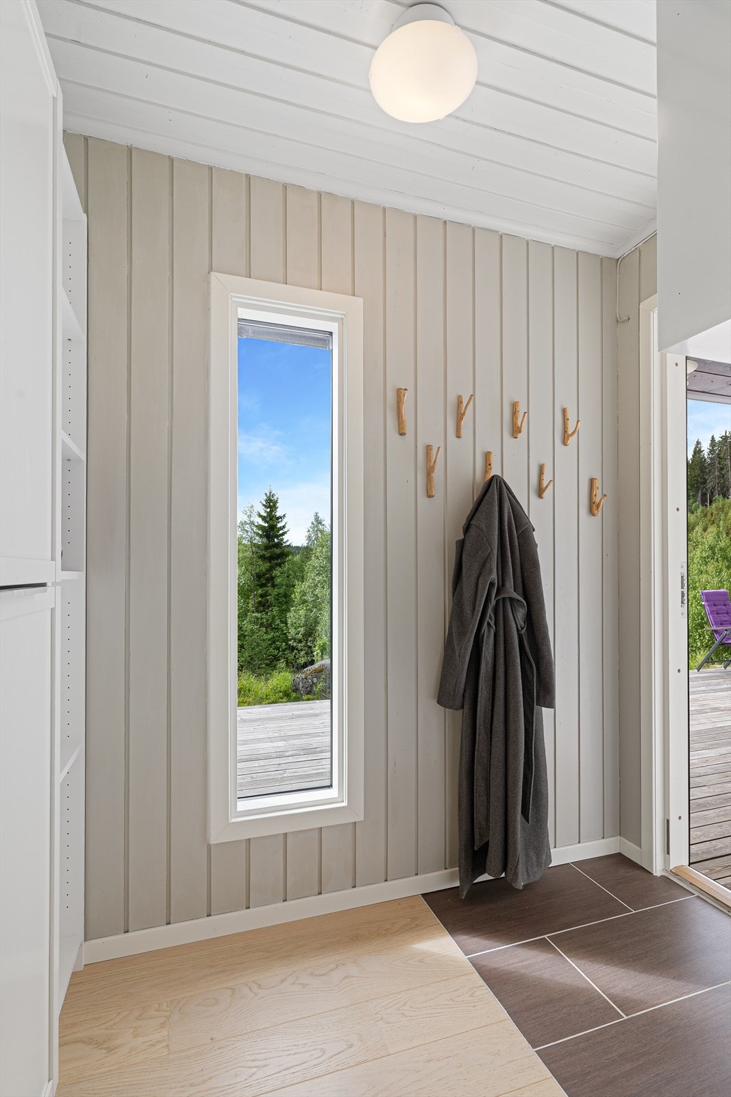 Entréen har praktiske fliser på gulvet og plass til å henge fra seg yttertøy. Galleribilde