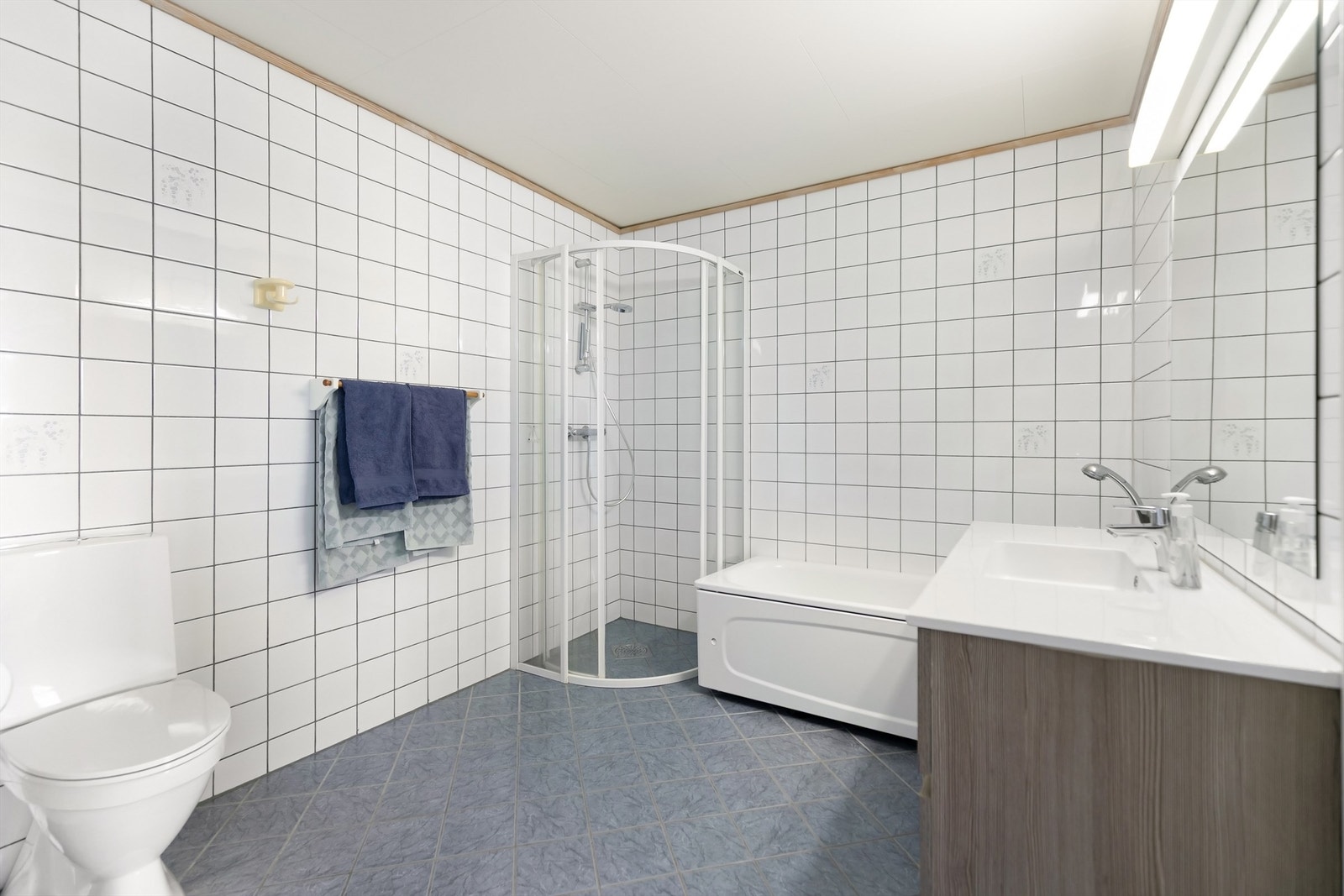 Badet i underetasjen har varmekabler, badekar med dusjløsning, toalett og servant. Galleribilde