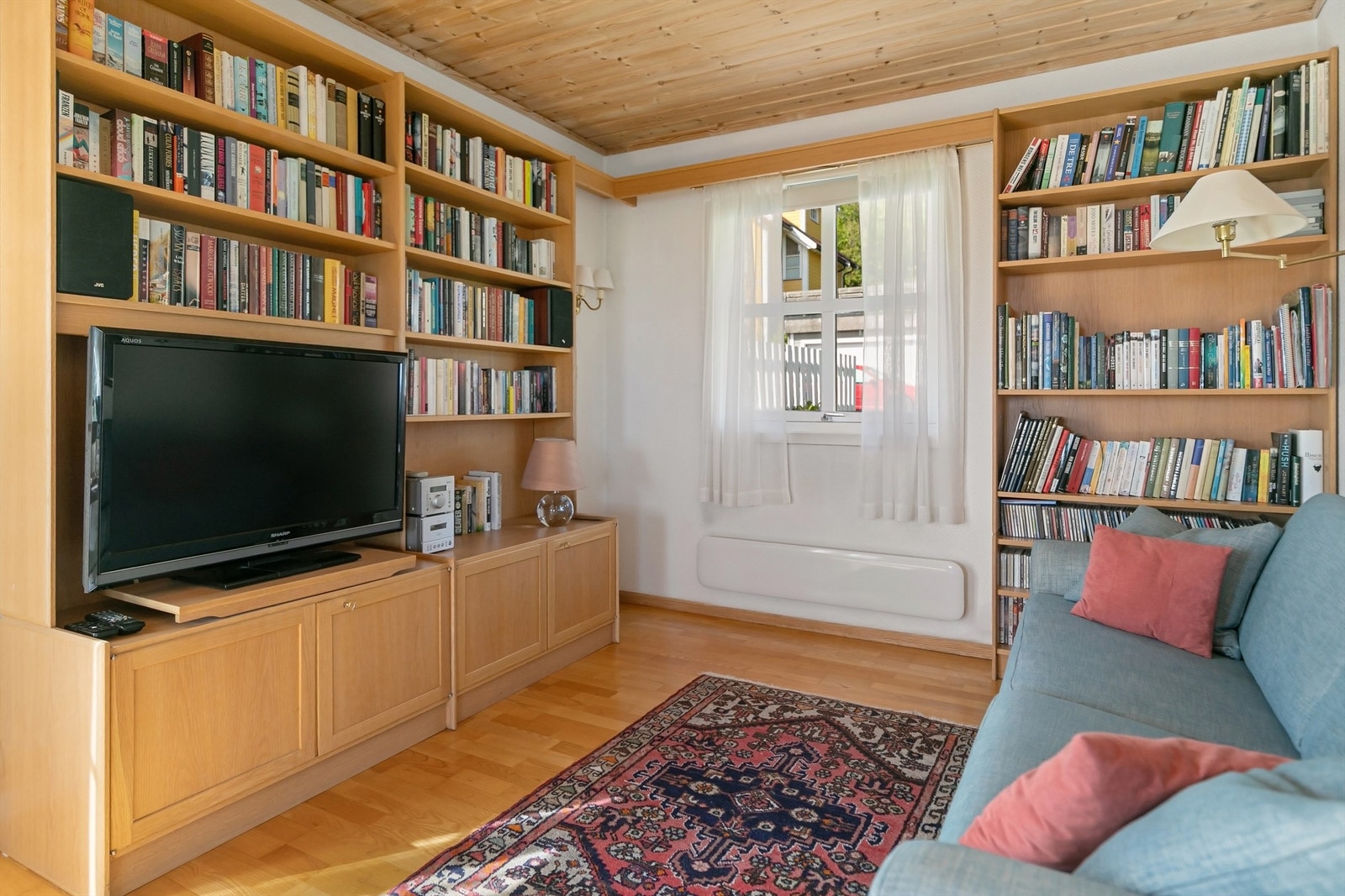 En del av stuen er innredet som bibliotek med plassbygde bokhyller. Galleribilde