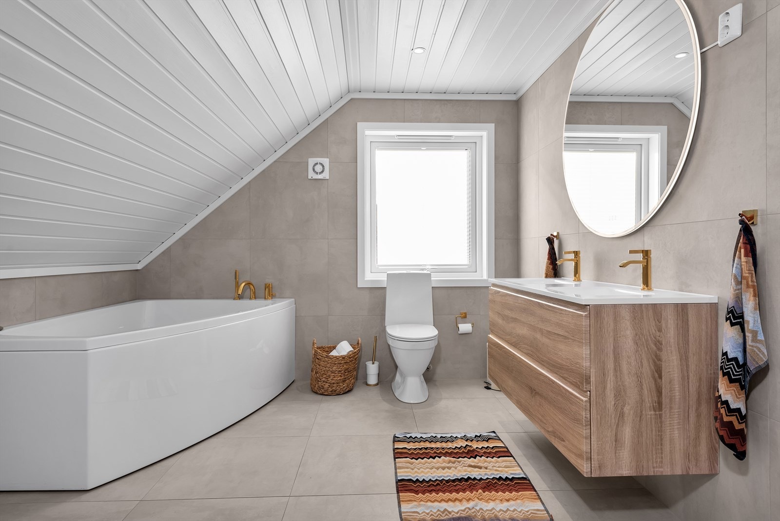 Lekkert baderom med stort badekar, toalett og baderomsinnredning med skuffer. Galleribilde