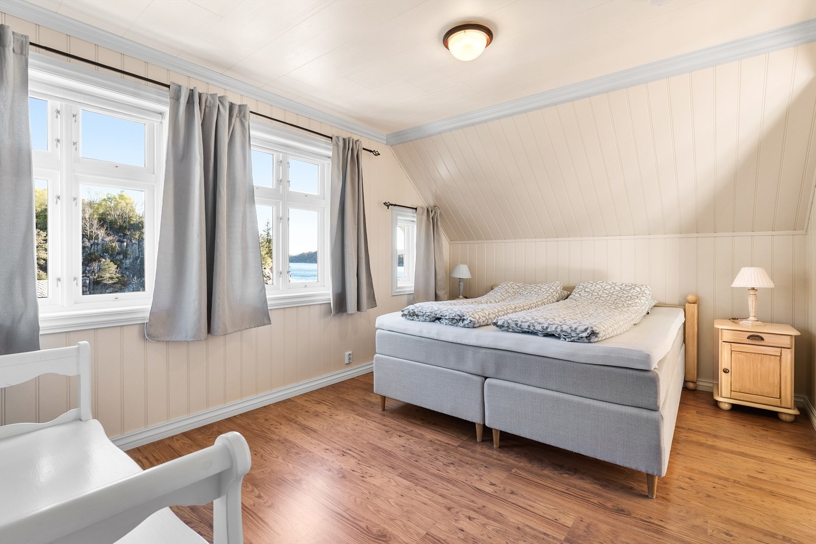 Ett av tre soverom på loftet, alle med laminatgulv og panelplater på veggene. Galleribilde