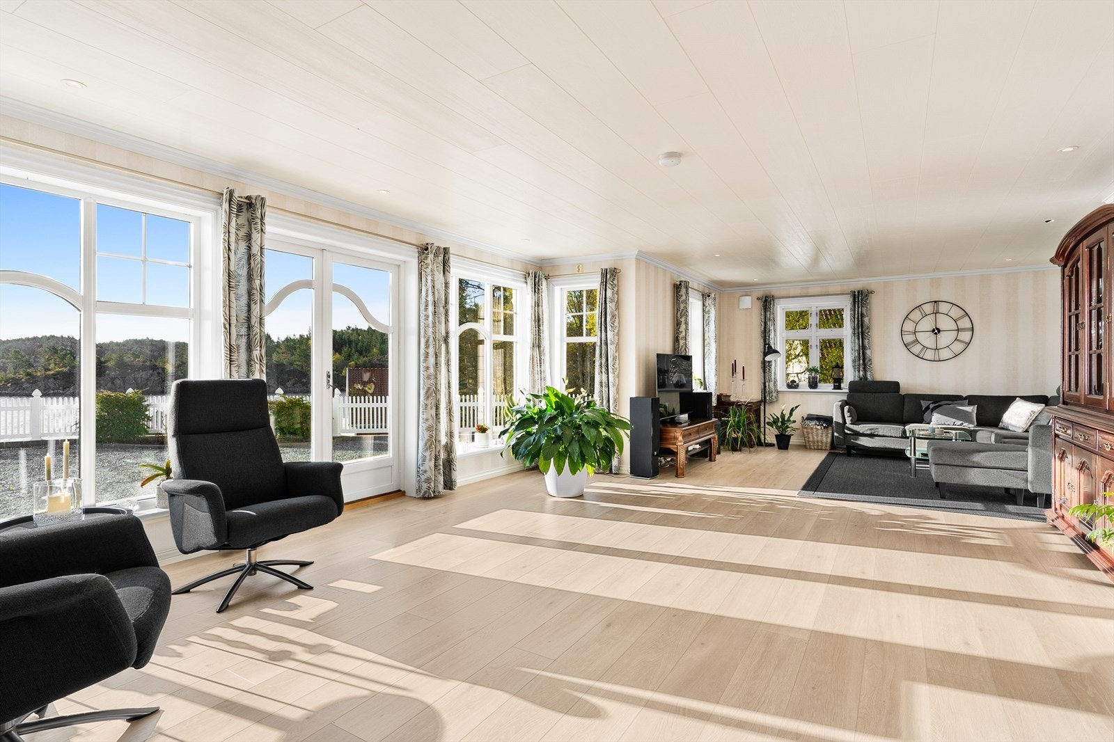 Stuen er romslig med plass til flere sittegrupper. Store vindusflater slipper inn rikelig med lys. Galleribilde