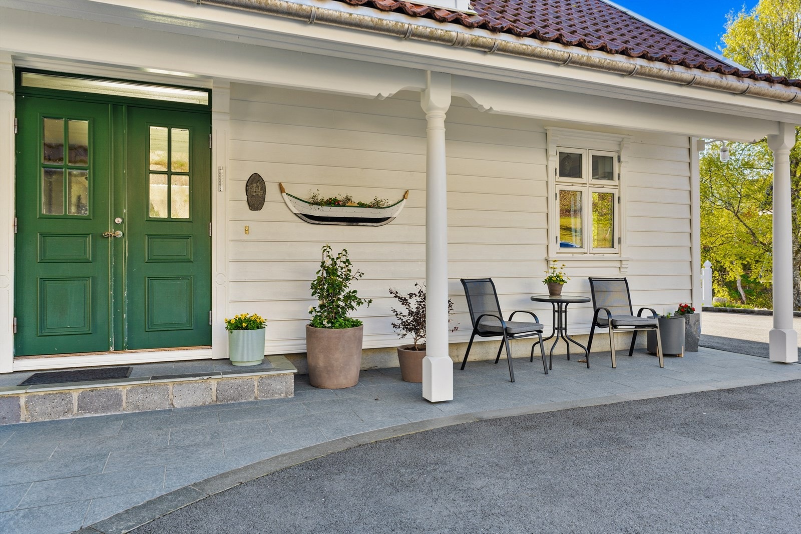 Overbygd inngangsparti med plass til en liten sittegruppe. Galleribilde