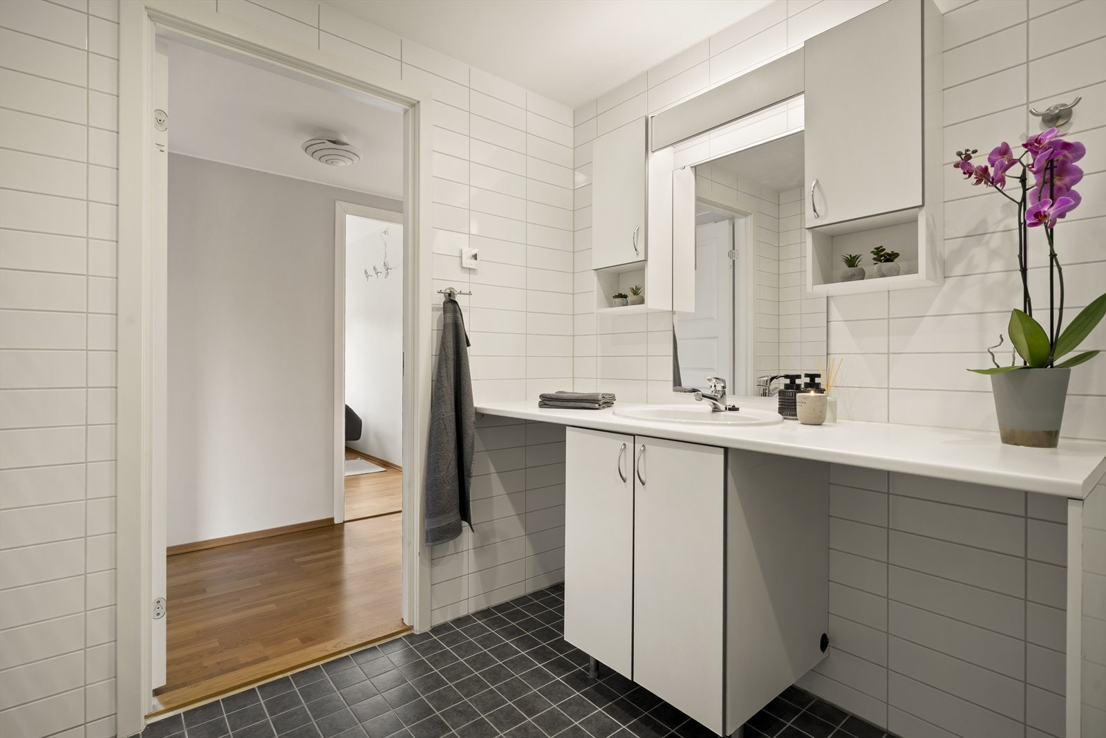 Badet er praktisk innredet med servant, god benkeplass og opplegg for vaskemaskin. Galleribilde