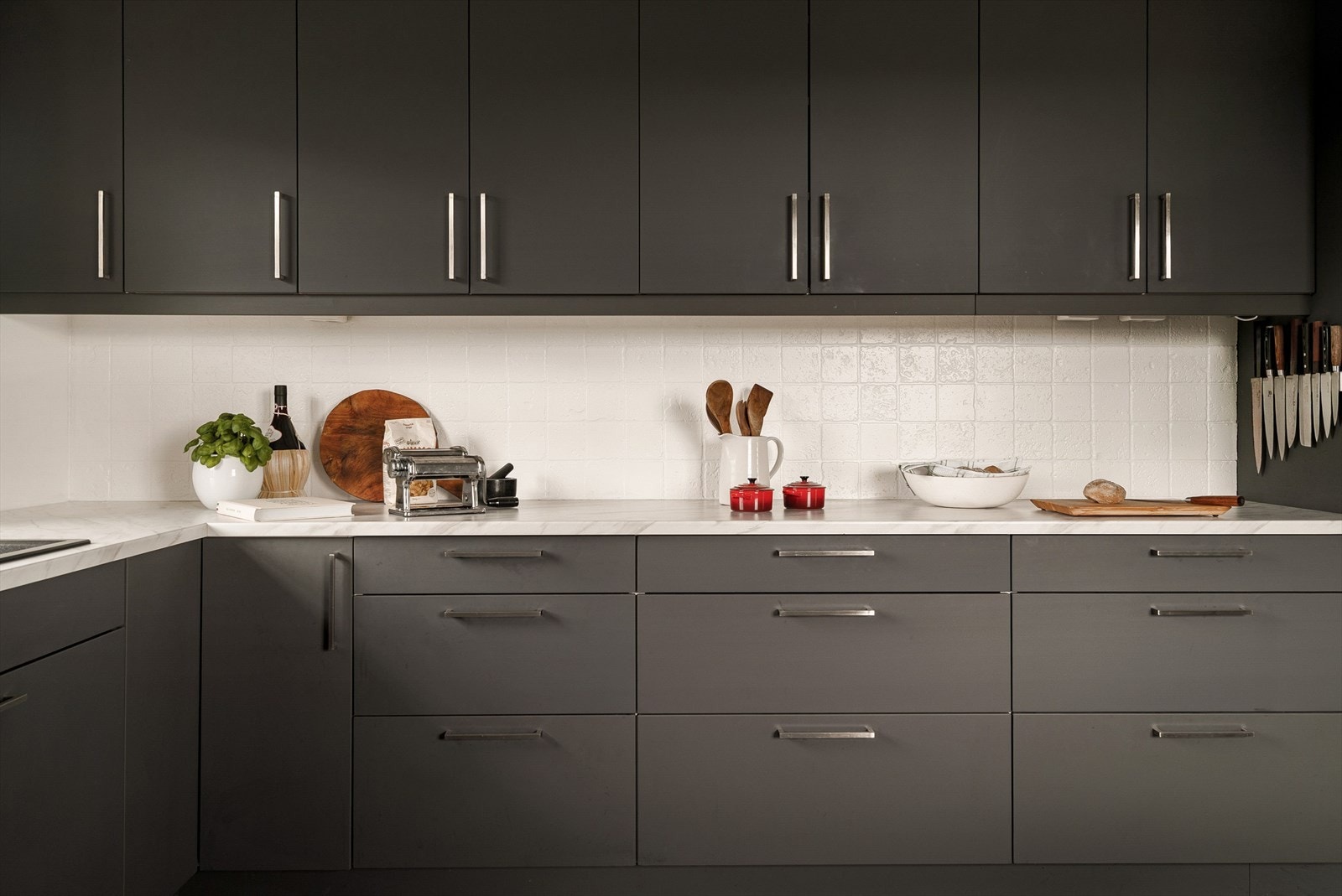 Moderne og stilrent kjøkken med glatte fronter og integrerte hvitevarer fra Siemens og Aeg som oppvaskmaskin, koketopp, kaffemaskin og stekeovn. Galleribilde