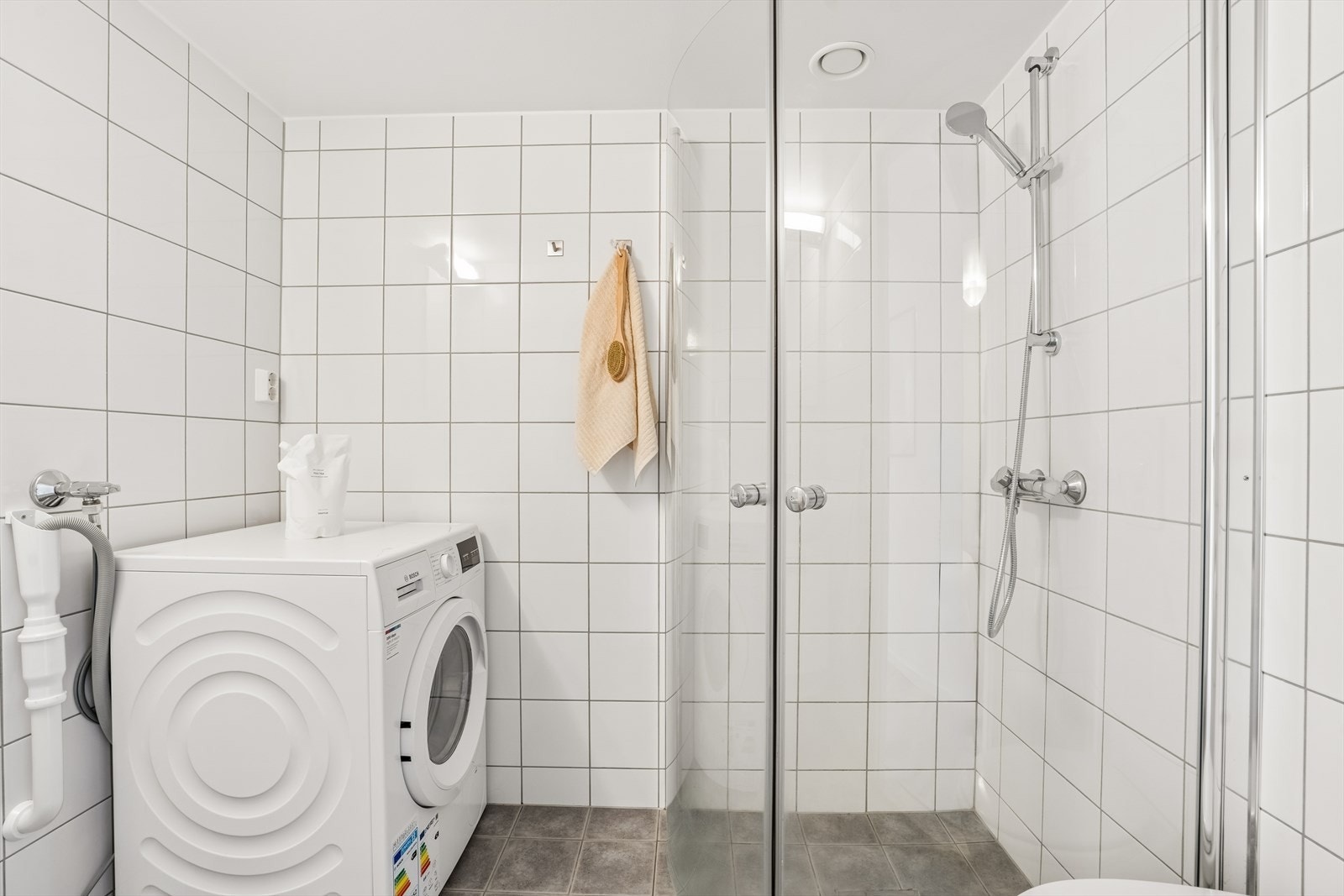 Badet inneholder dusjhjørne med glassvegger, baderomsinnredning samt opplegg for vaskemaskin. Galleribilde