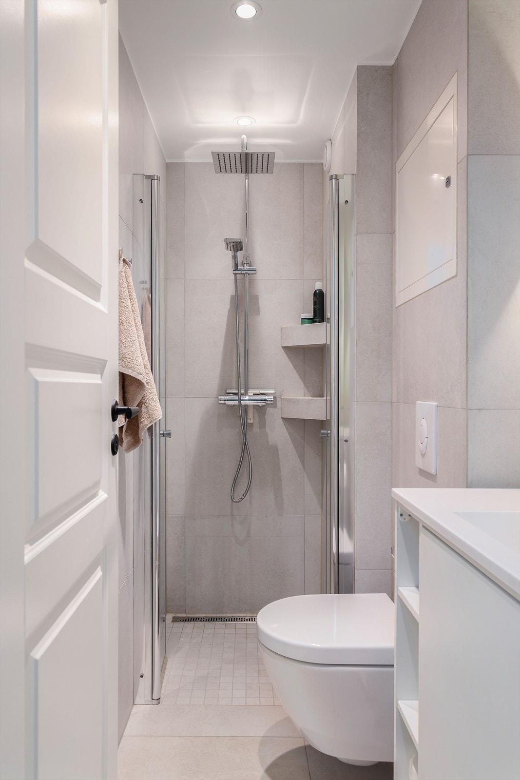 Baderom i tilknytning med entrèen er et pent og moderne baderom fra 2018, med flislagte gulv og vegger, elektrisk gulvvarme, downlights i himling og mekanisk avtrekk. Galleribilde