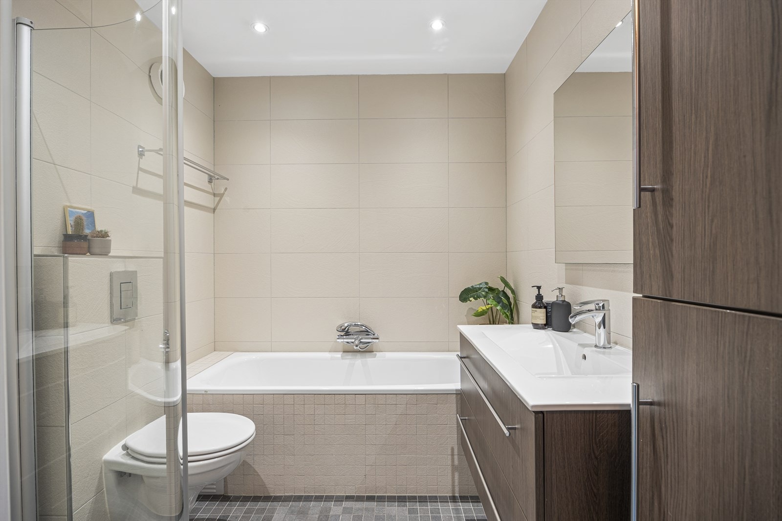 Badet fremstår som funksjonelt og tidløst, med fliser på både vegger og gulv samt malt himling. Galleribilde