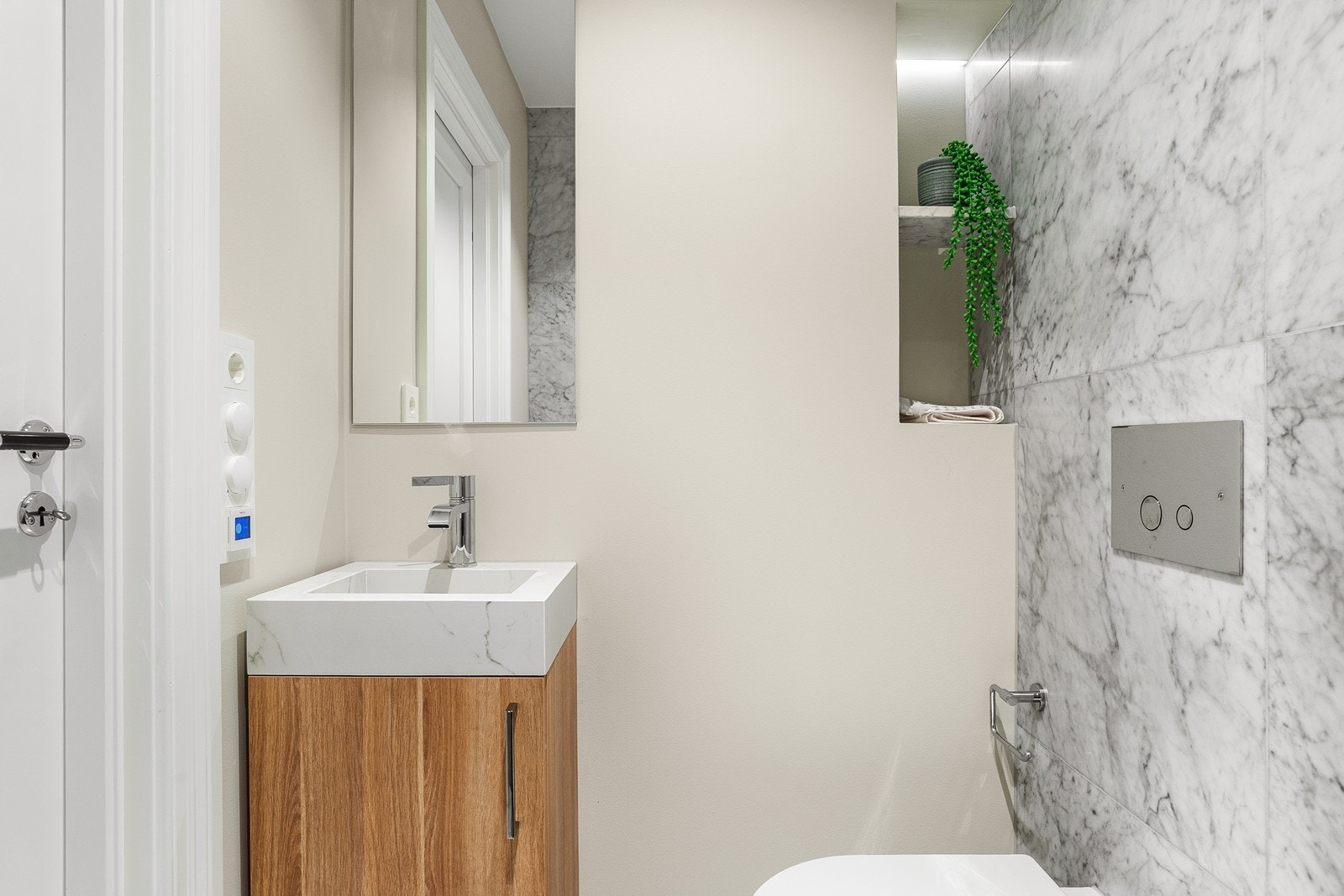 Badet er bygget i samme eksklusive stil med en flott kombinasjon av eik og marmor Galleribilde
