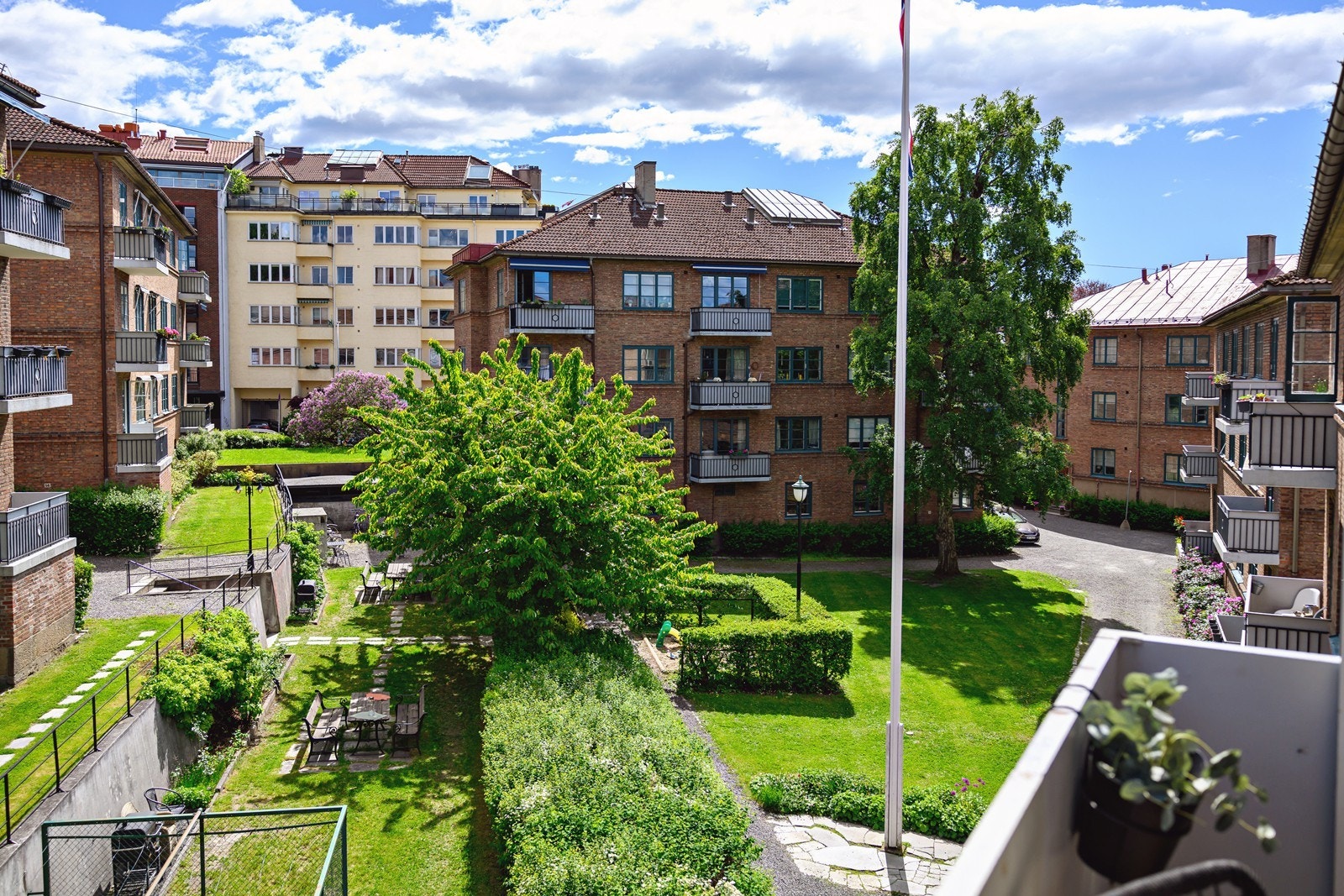 Hyggelig utsyn fra balkongen mot grønt og frodig fellesareal Galleribilde