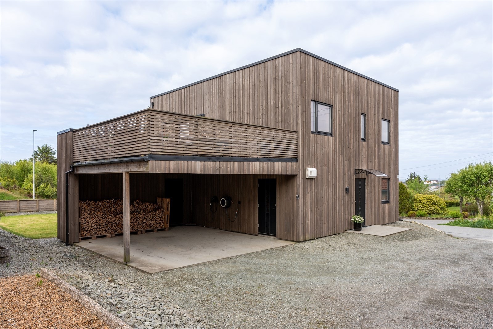 Praktisk carport med tilhørende utvendig bod gir gode oppbevaringsmuligheter. Fra carporten er det direkte adkomst til boligens romslige vaskerom, noe som gir en svært funksjonell løsning i hverdagen. Galleribilde