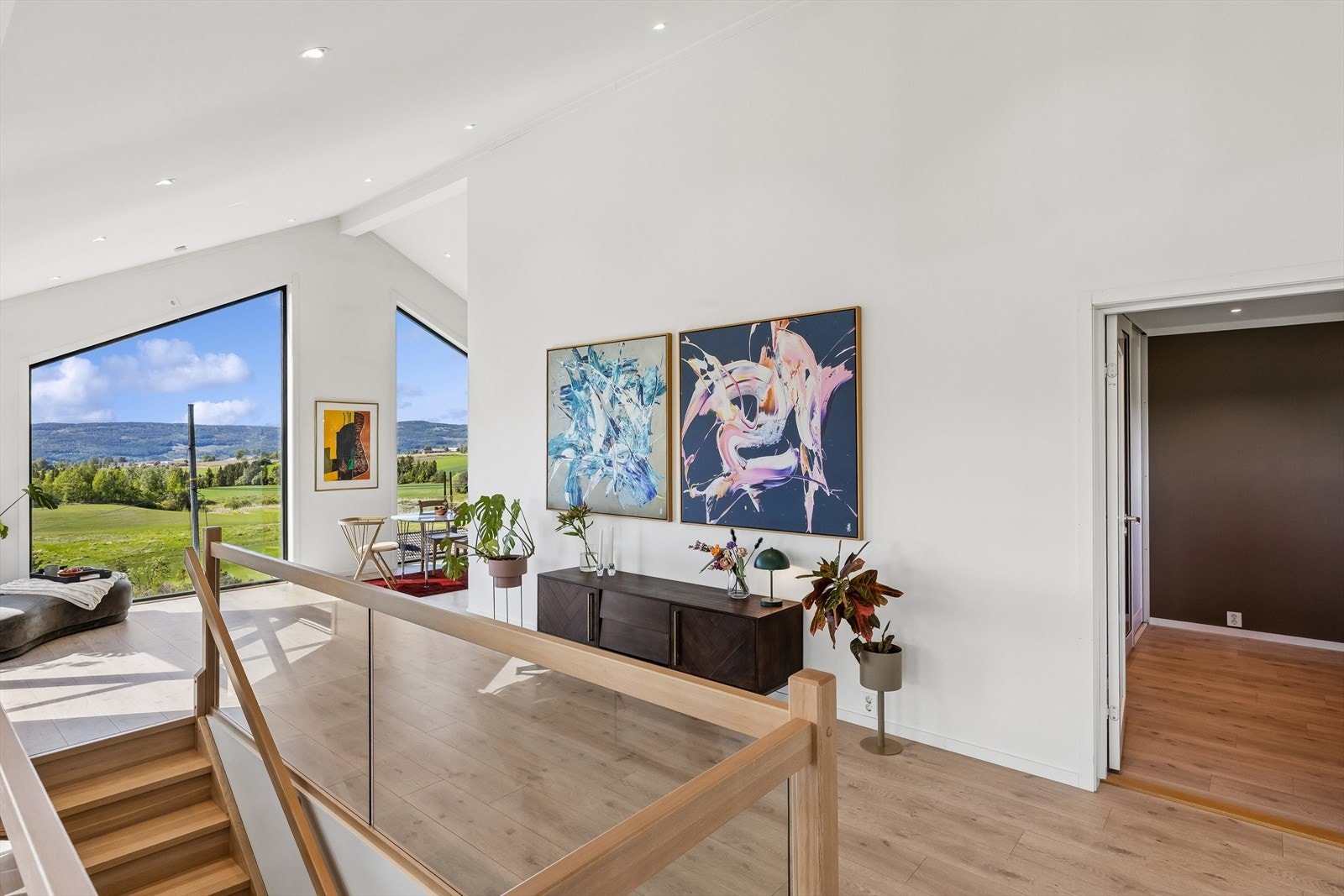 Tretrappen binder de to etasjene sammen, og rekkverk i glass bevarer den åpne romfølelsen. Galleribilde