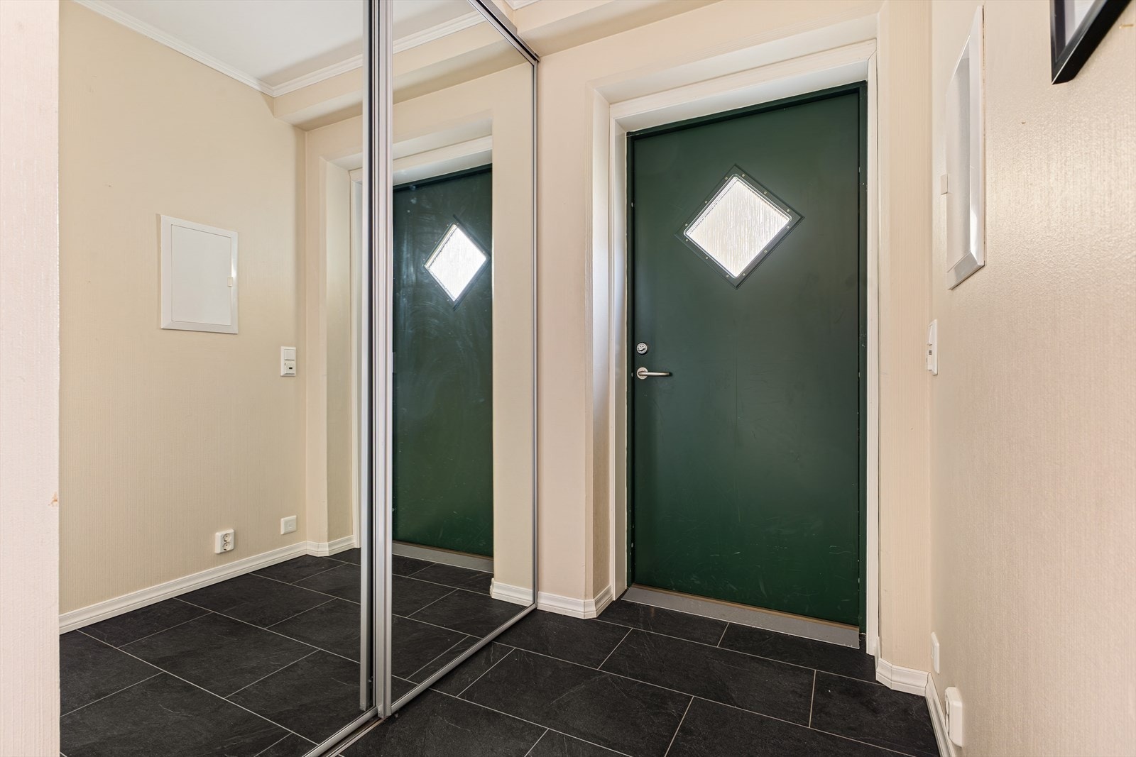 Romslig entrésone i gang med skyvedørsgarderobe med speilfronter Galleribilde