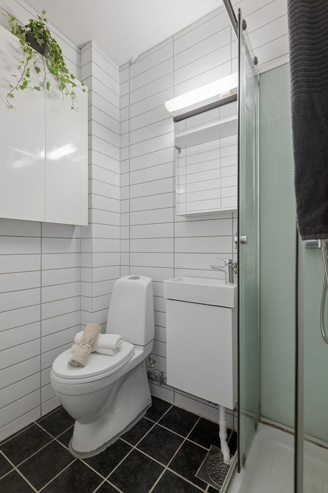 Badet har et moderne preg med flislagte overflater og stilrene detaljer Galleribilde