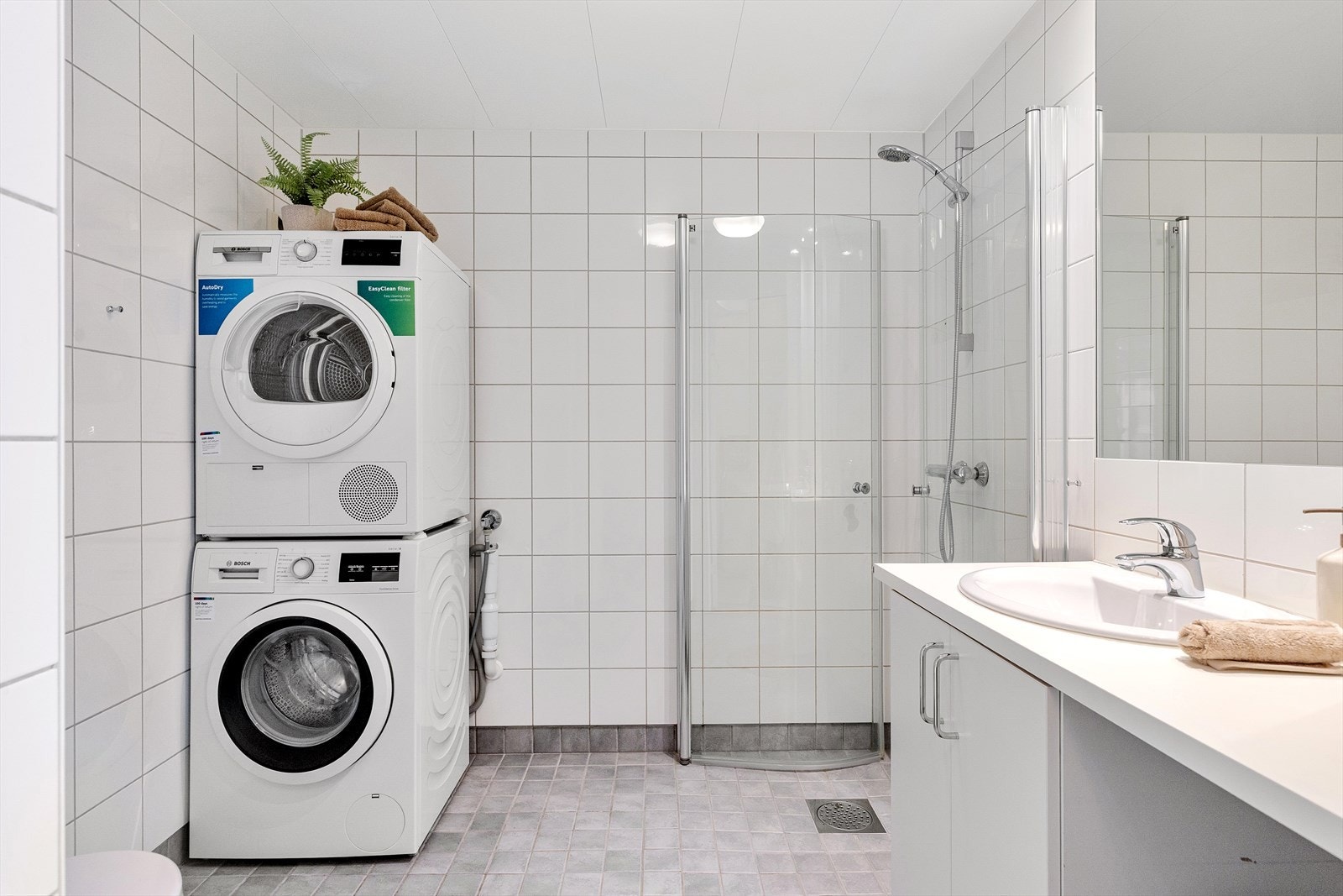 Pent og flislagt baderom med gulvvarme og downlights i himlingen. Galleribilde