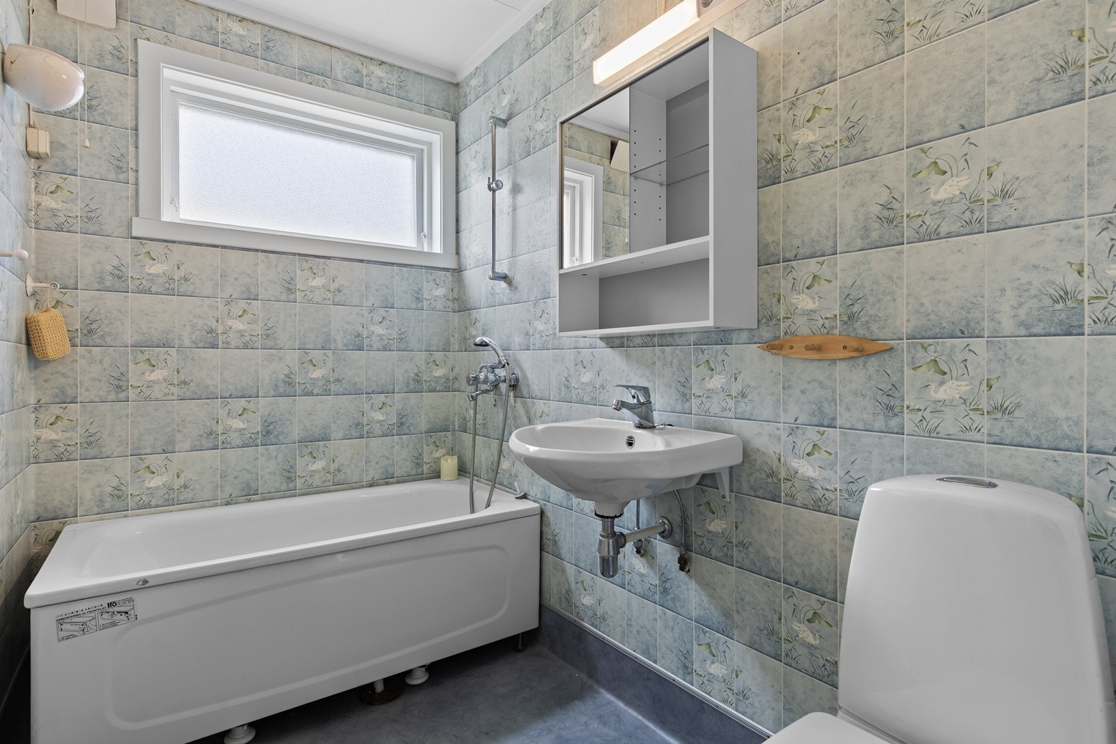 Badet har våtromstapet på vegger og belegg på gulv, samt installert badekar, wc og servant. Galleribilde