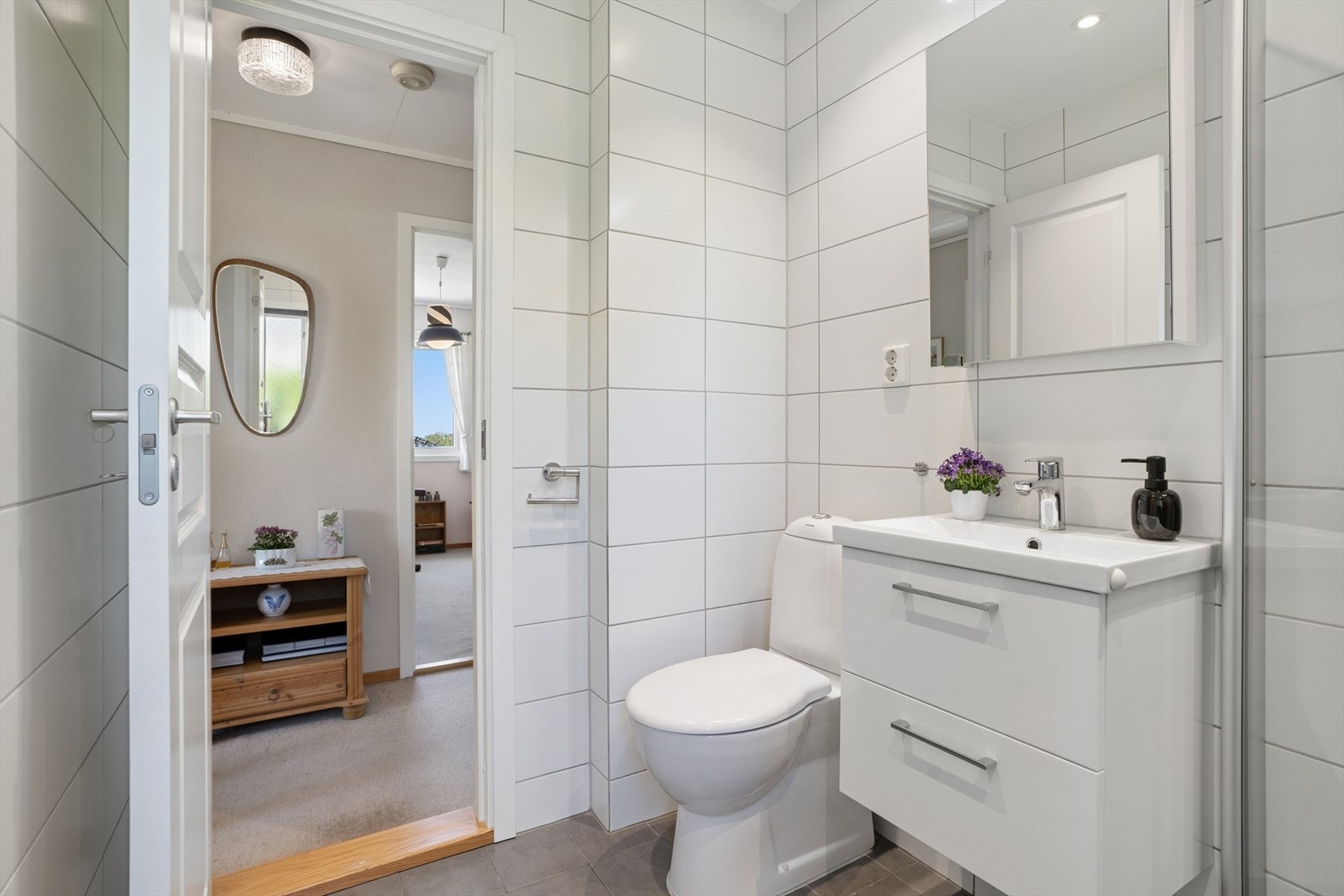 Badet har innredning med nedfelt servant, toalett og dusjhjørne med glassvegger. Galleribilde
