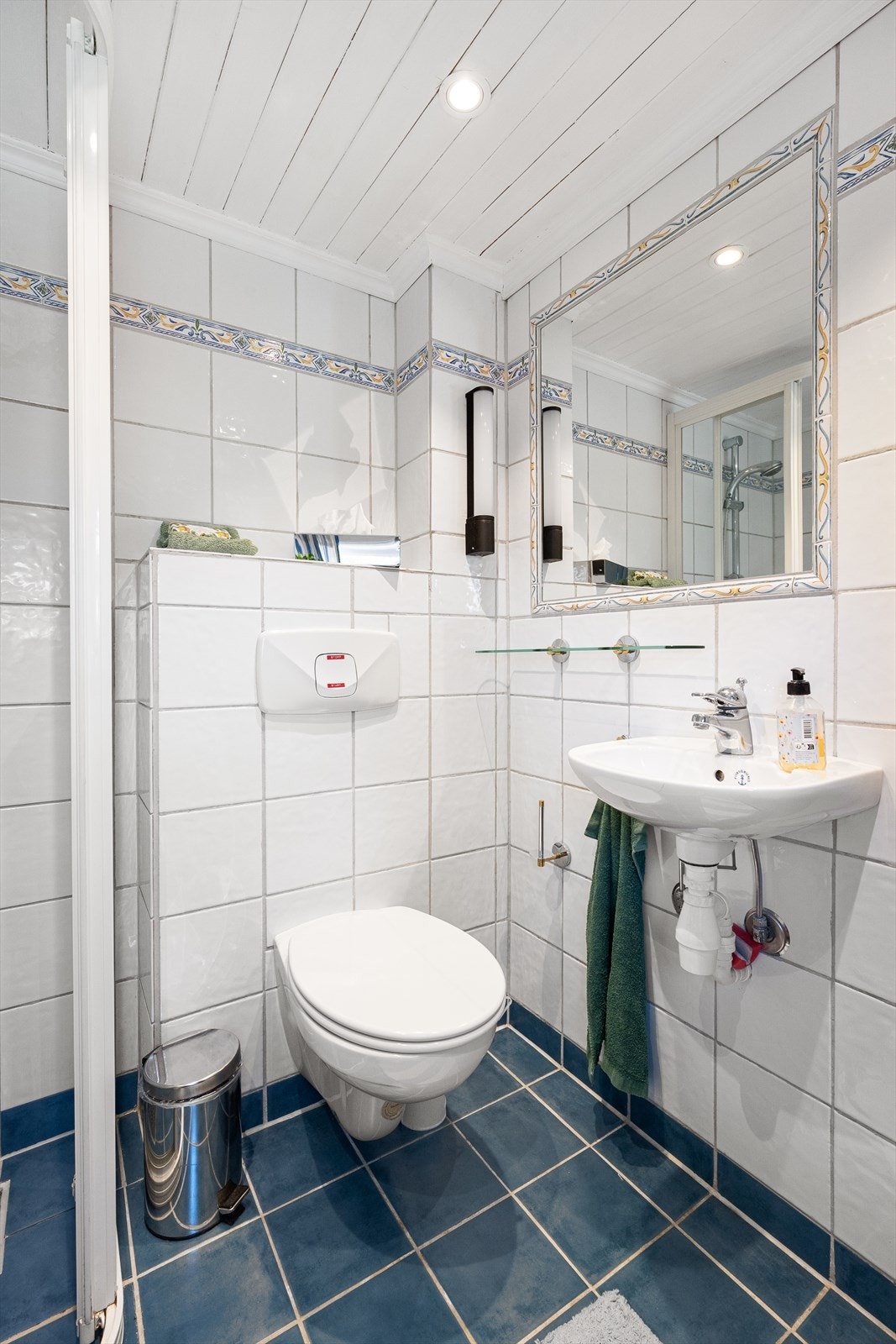 Badet er utstyrt med vegghengt toalett, servant og dusjhjørne. Galleribilde
