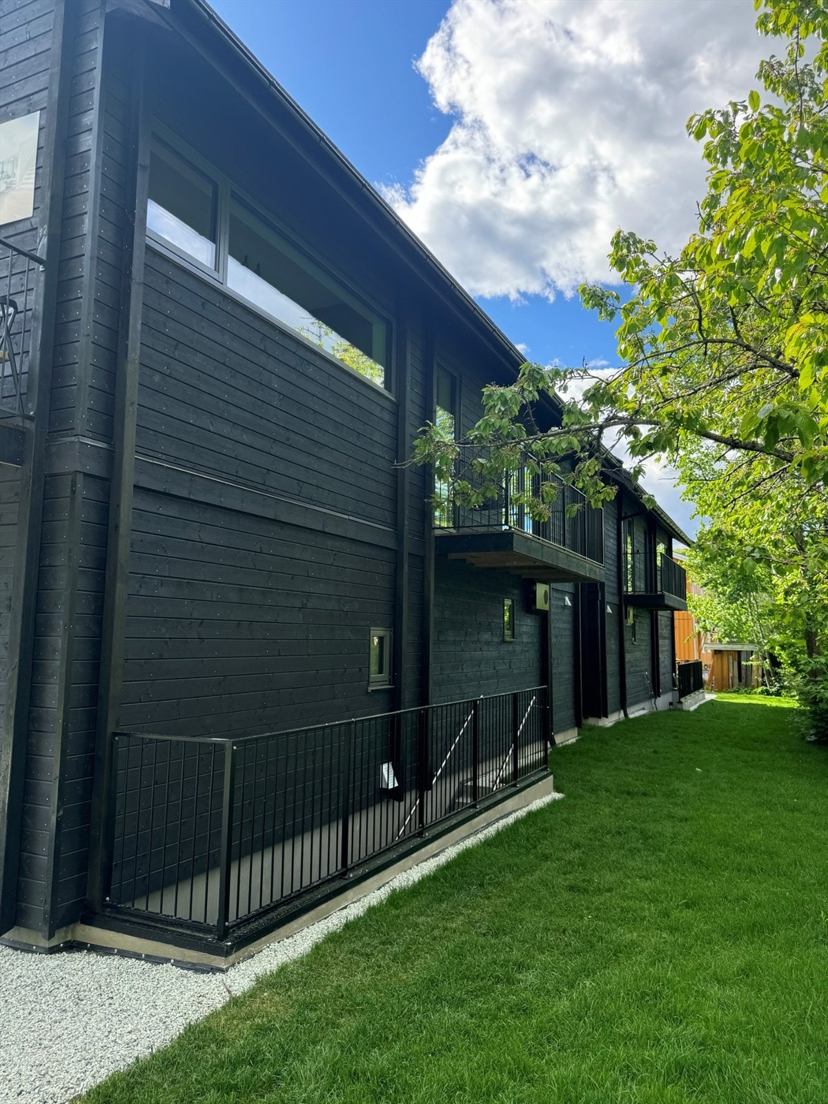Bak huset har man en egen inngang til boligens underetasje samt en hageflekk. Galleribilde