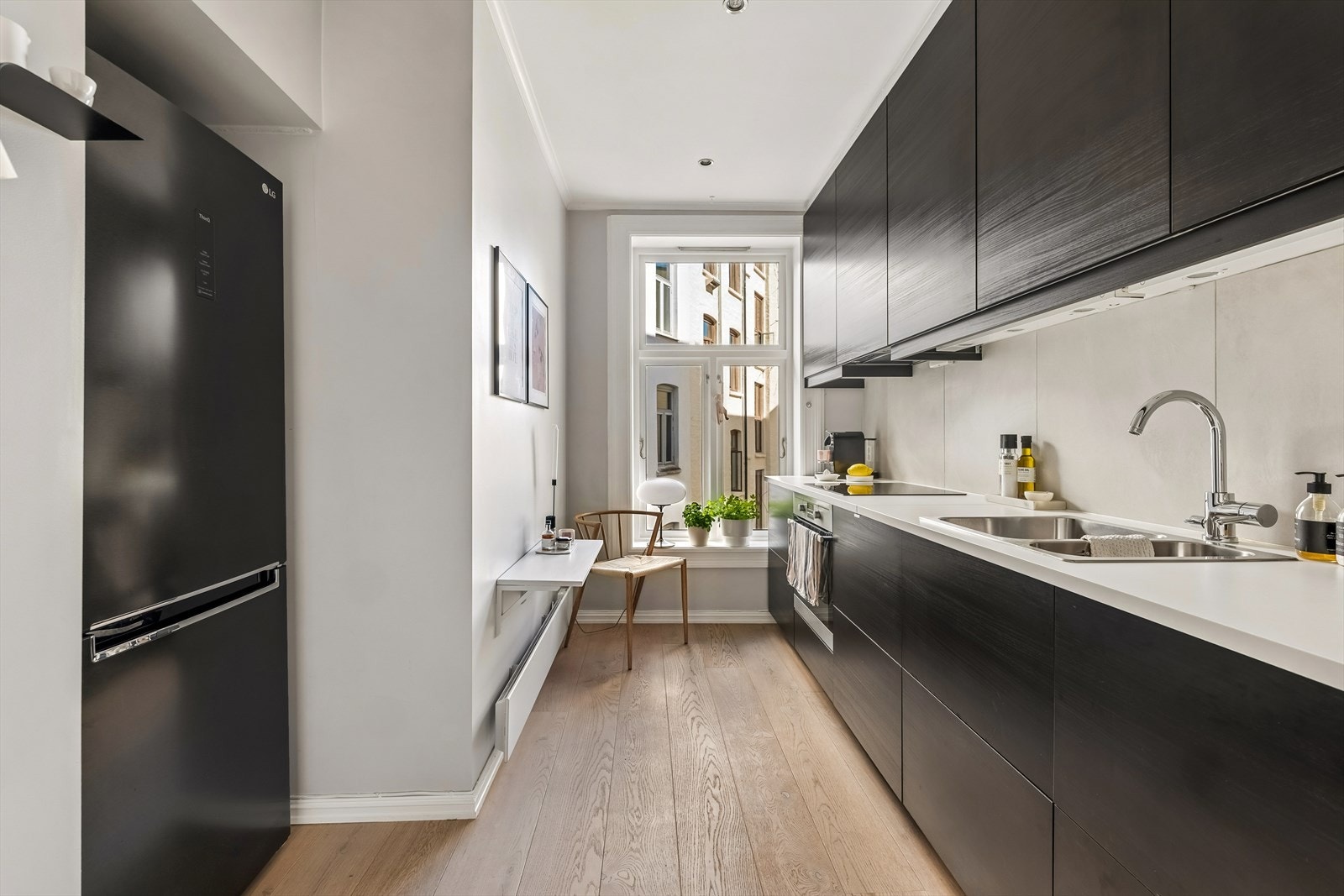 Kjøkkenet er adskilt fra stuen med direkte adkomst fra entréen. Det er et moderne IKEA kjøkken fra 2017 som er innredet med glatte finerte fronter og benkeplate av laminat. Galleribilde