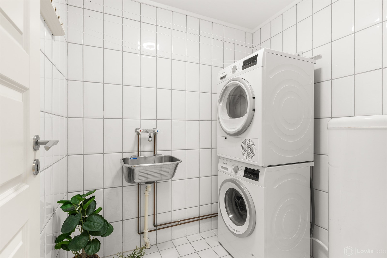 Praktisk, separat vaskerom med flislagt gulv, gulvvarme og opplegg for vaskemaskin. Galleribilde