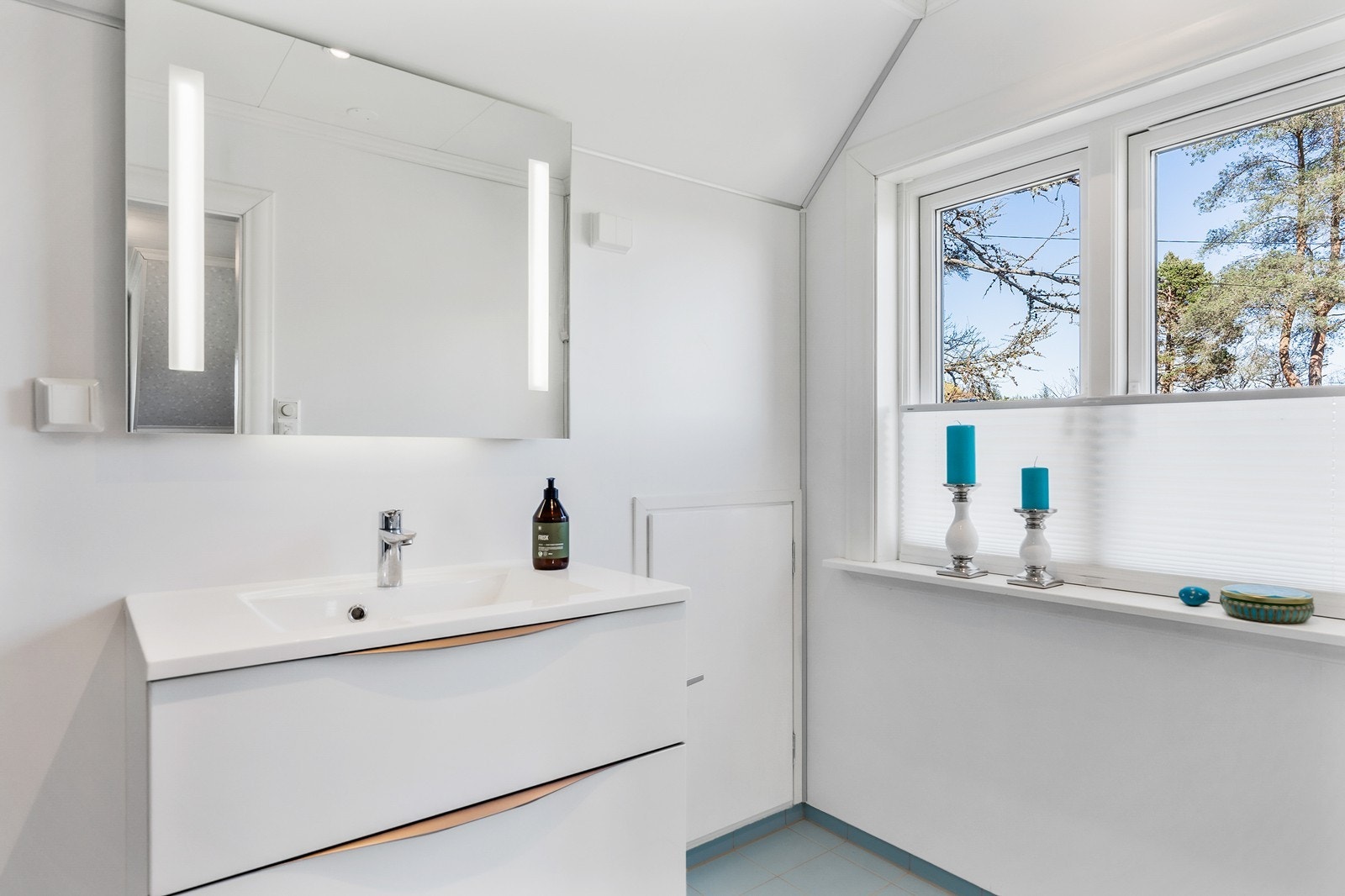 Badet er innredet med servant med underskap, speil med lys, dusjkabinett og WC. Galleribilde