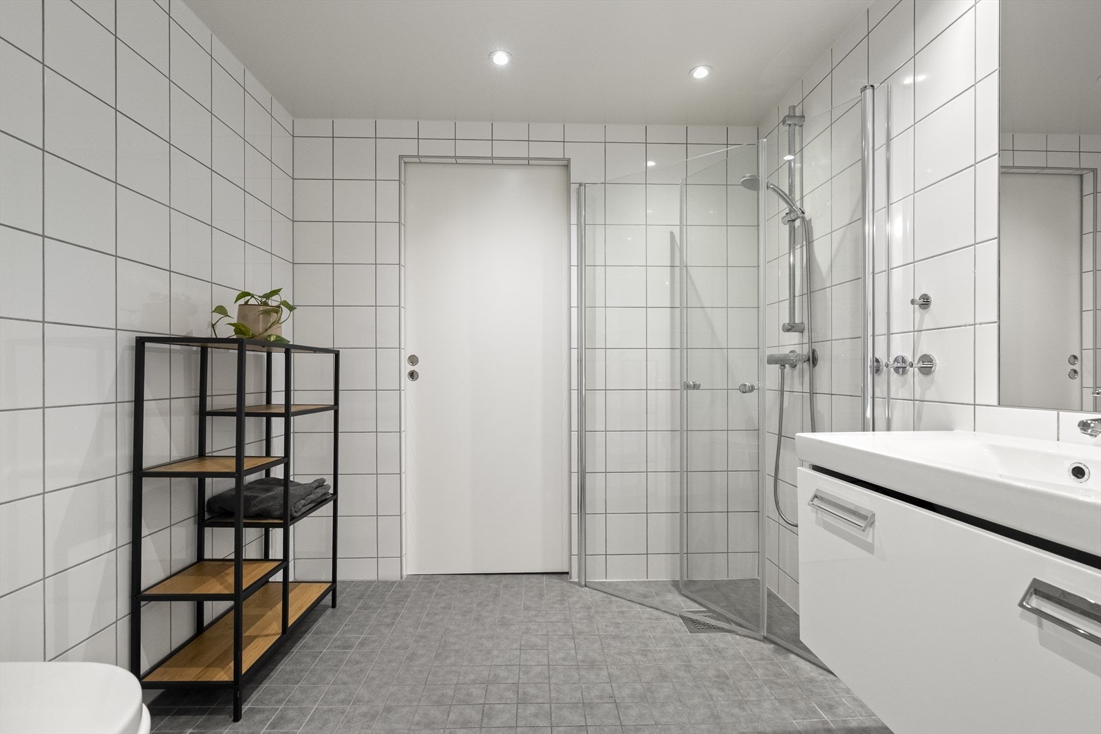 - Badet er innredet med vegghengt toalett, servant i underskap, speil og dusjhjørne. Det er også adskilt vaskerom med skyvedør fra bad - Galleribilde
